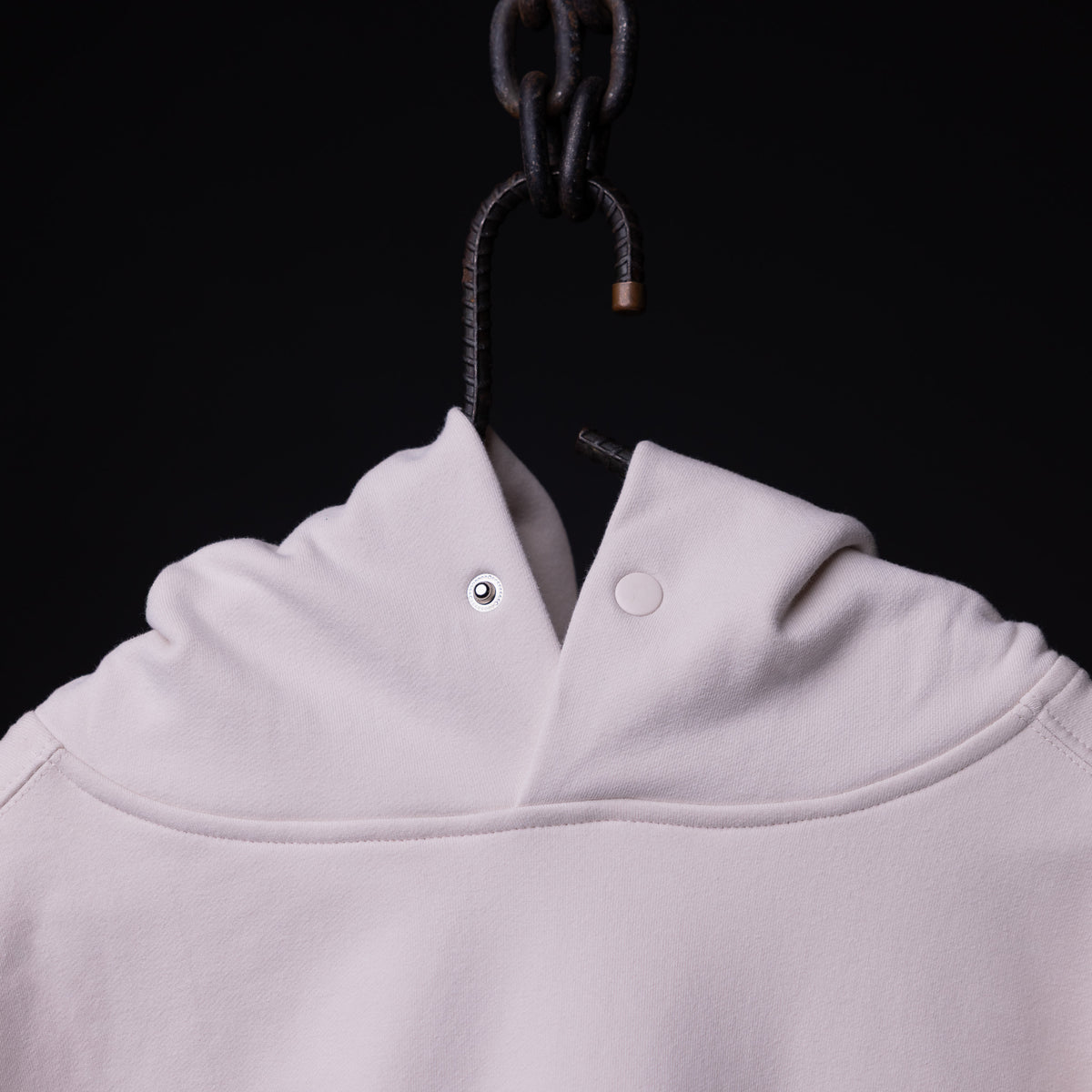 Tech Terry Eagle Hoodie in light pink, displayed on hanger showing hood and collar detail