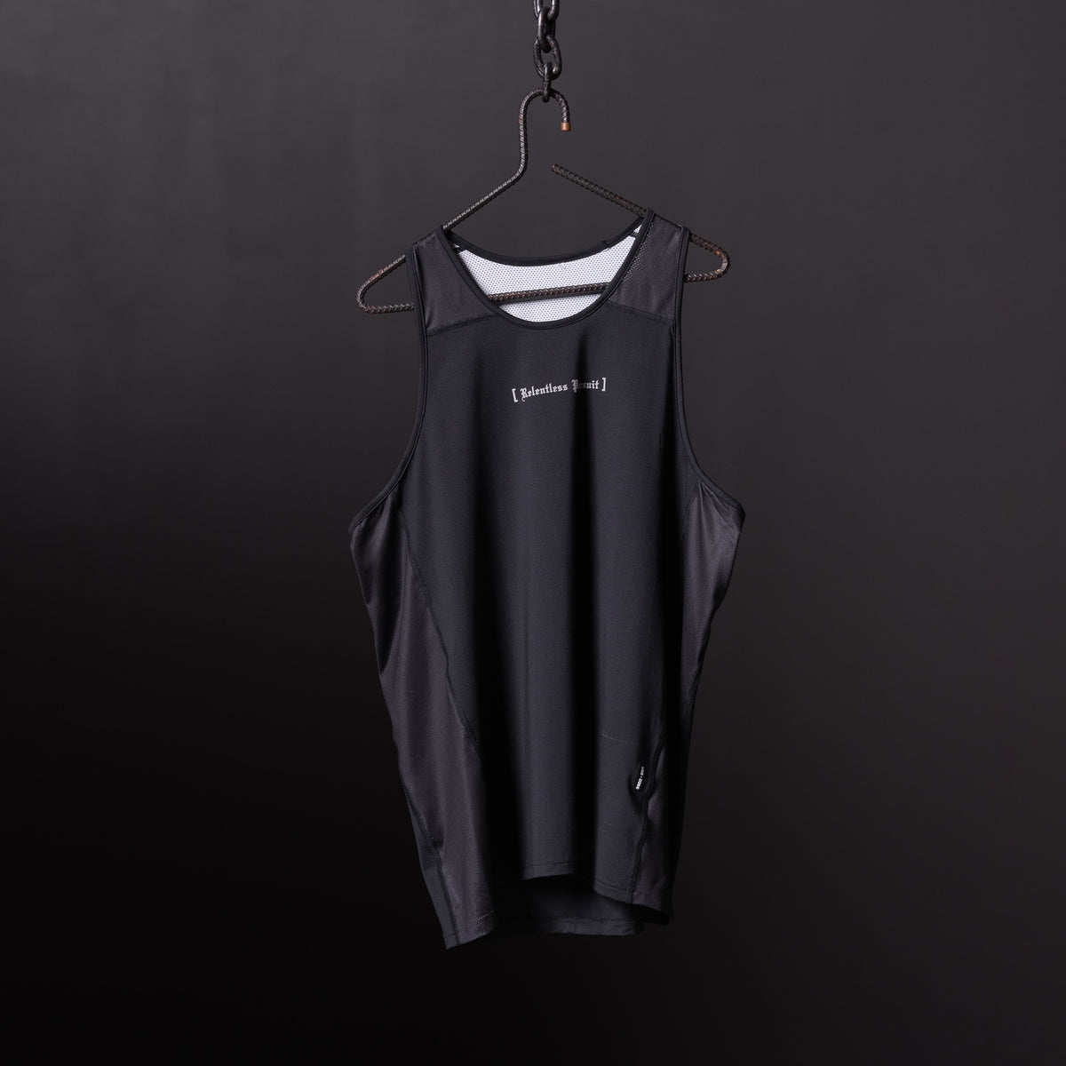Black singlet tank on hanger against dark background, front view