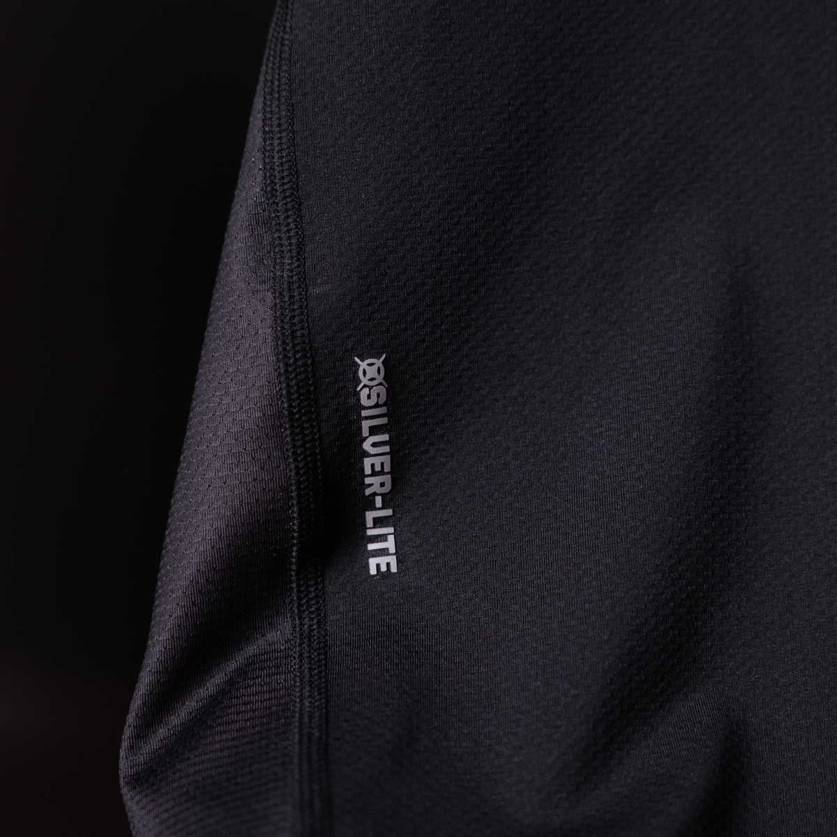 SM'19 Singlet Tank in black, detail shot of side seam and branding label