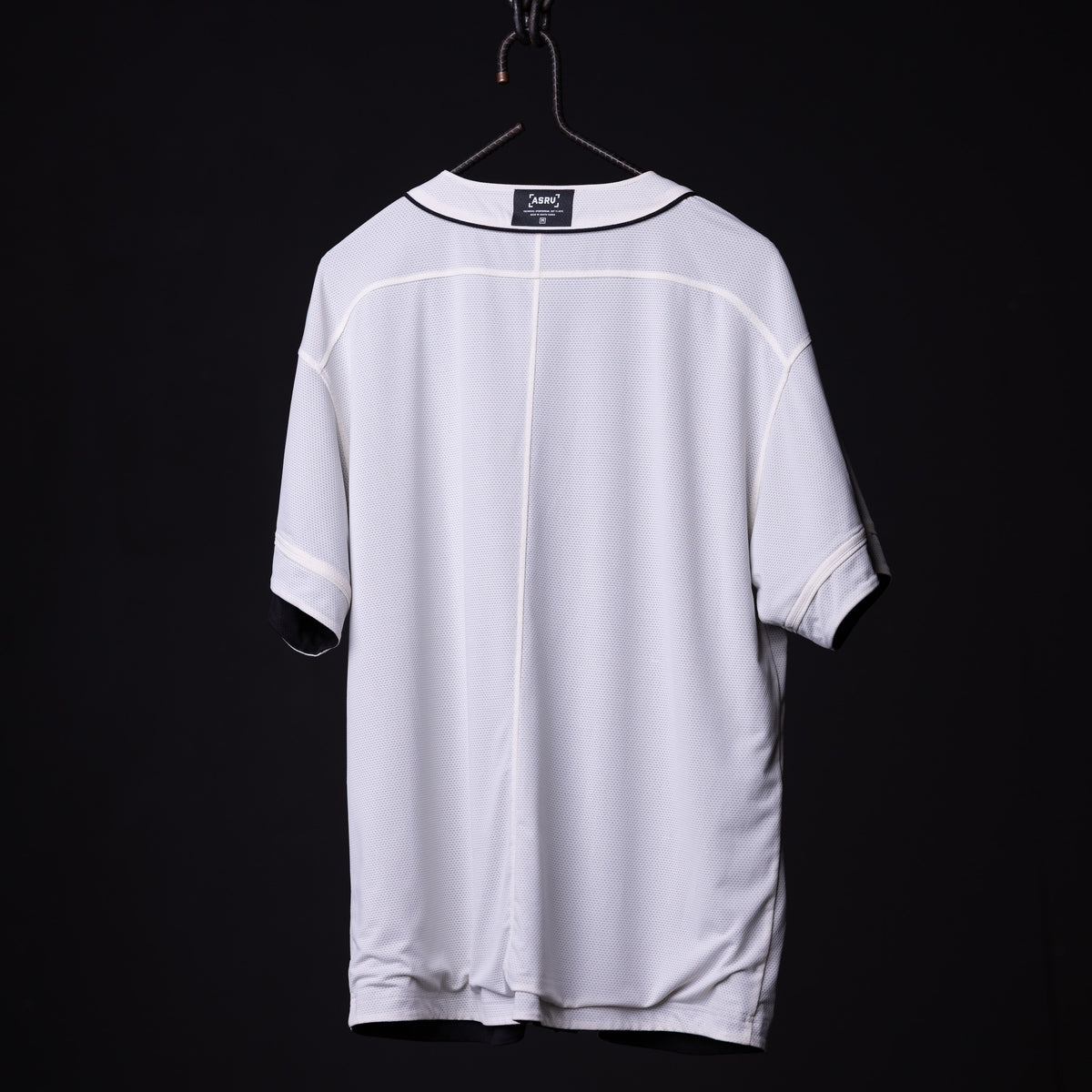 FA'21 Reversible Jersey in white, displayed on hanger against black background, back view