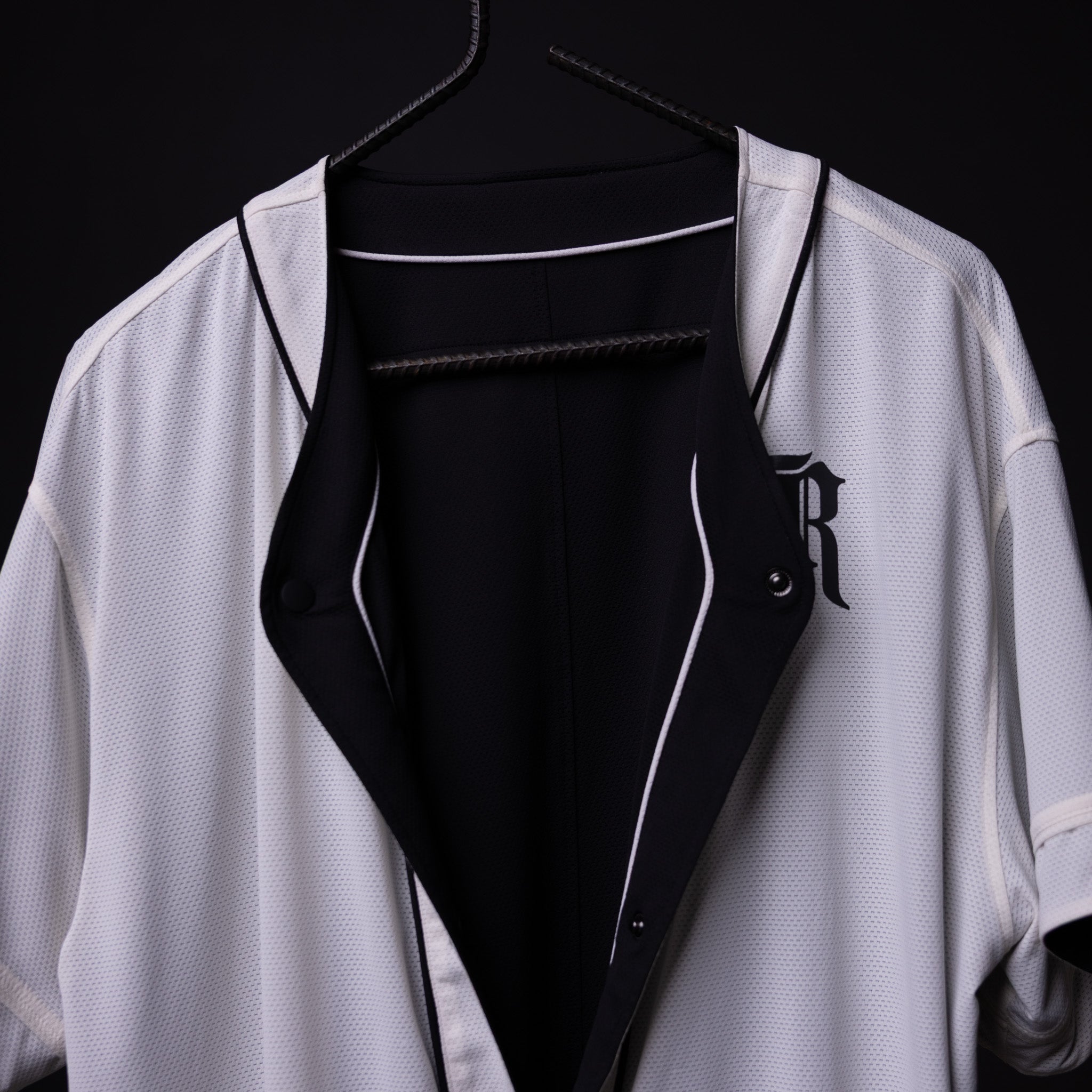 FA'21 Reversible Jersey in white and black, displayed on hanger showing front open view
