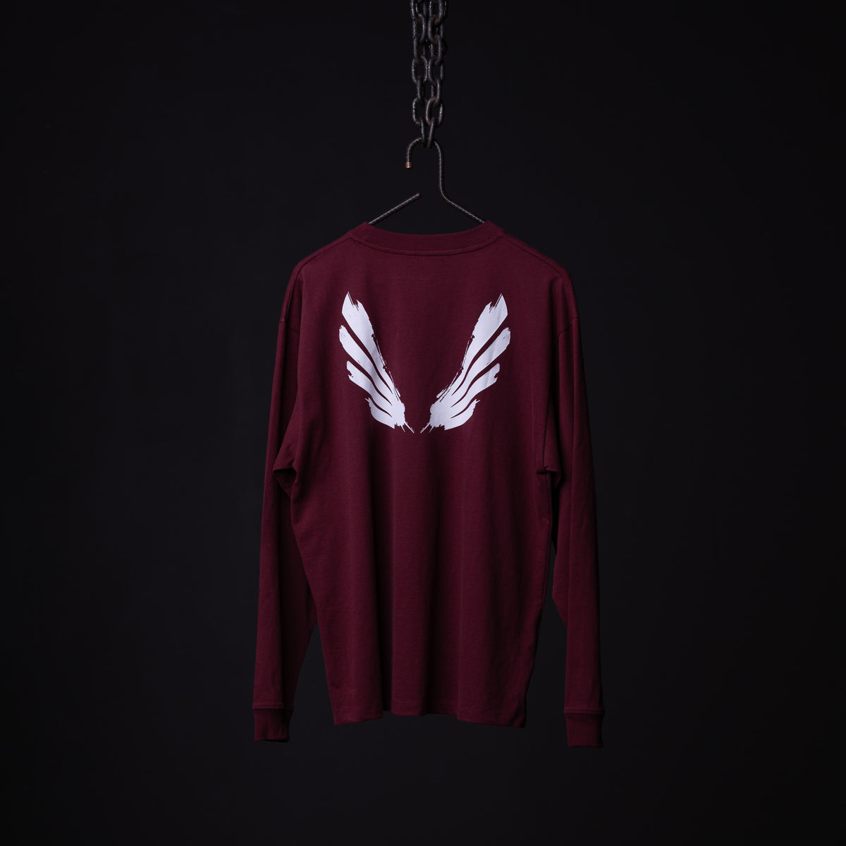 SM'22 Graphic Long Sleeve in maroon with white wing design on back, displayed on hanger