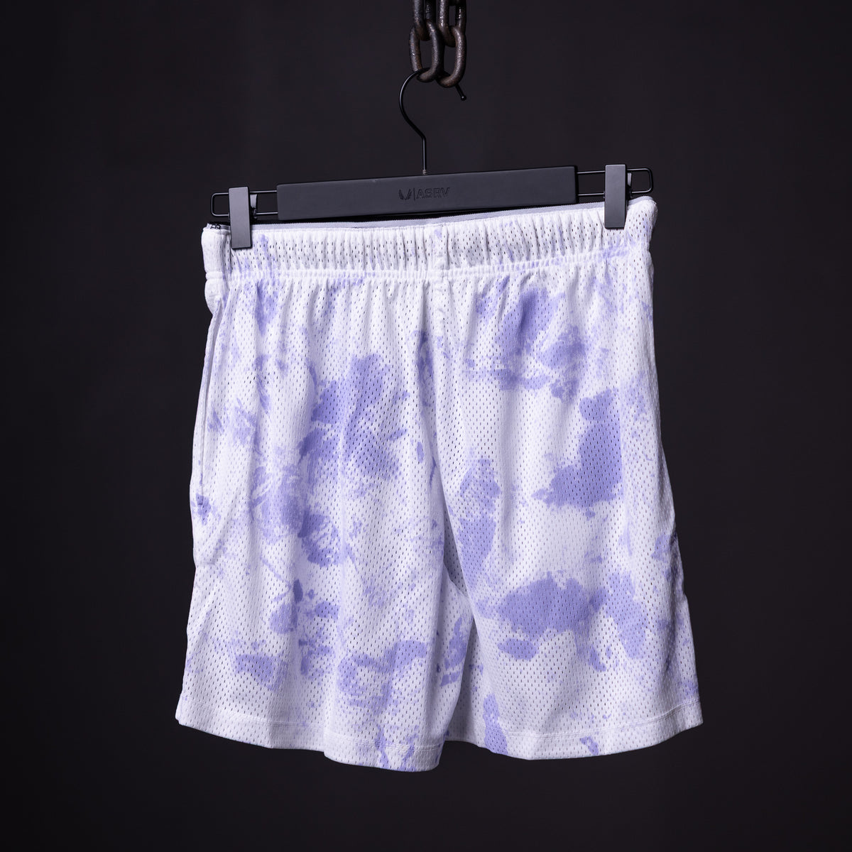 SM'22 Tie Dye Painted Short in purple and white, hung on black hanger against dark background
