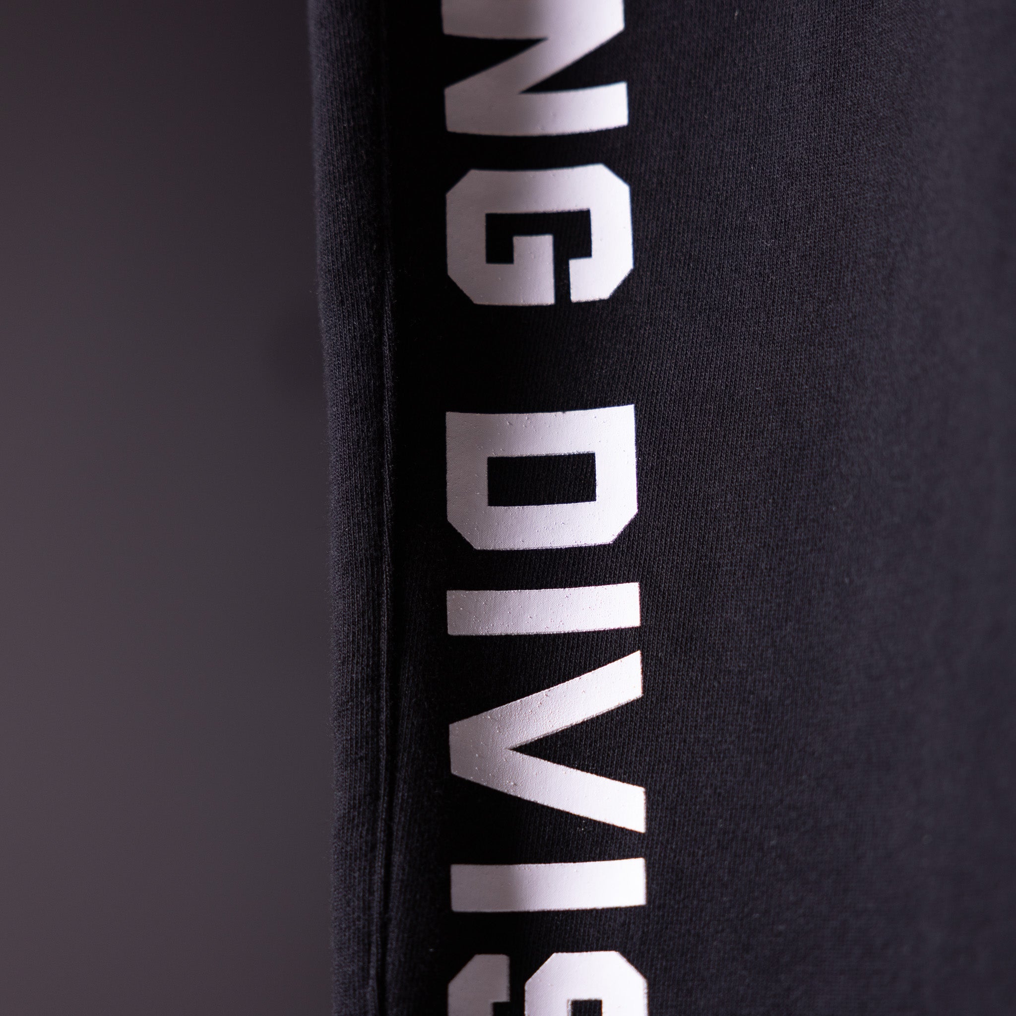 FA'23 Straight Leg Jogger in black with white branding, detail shot of side seam text