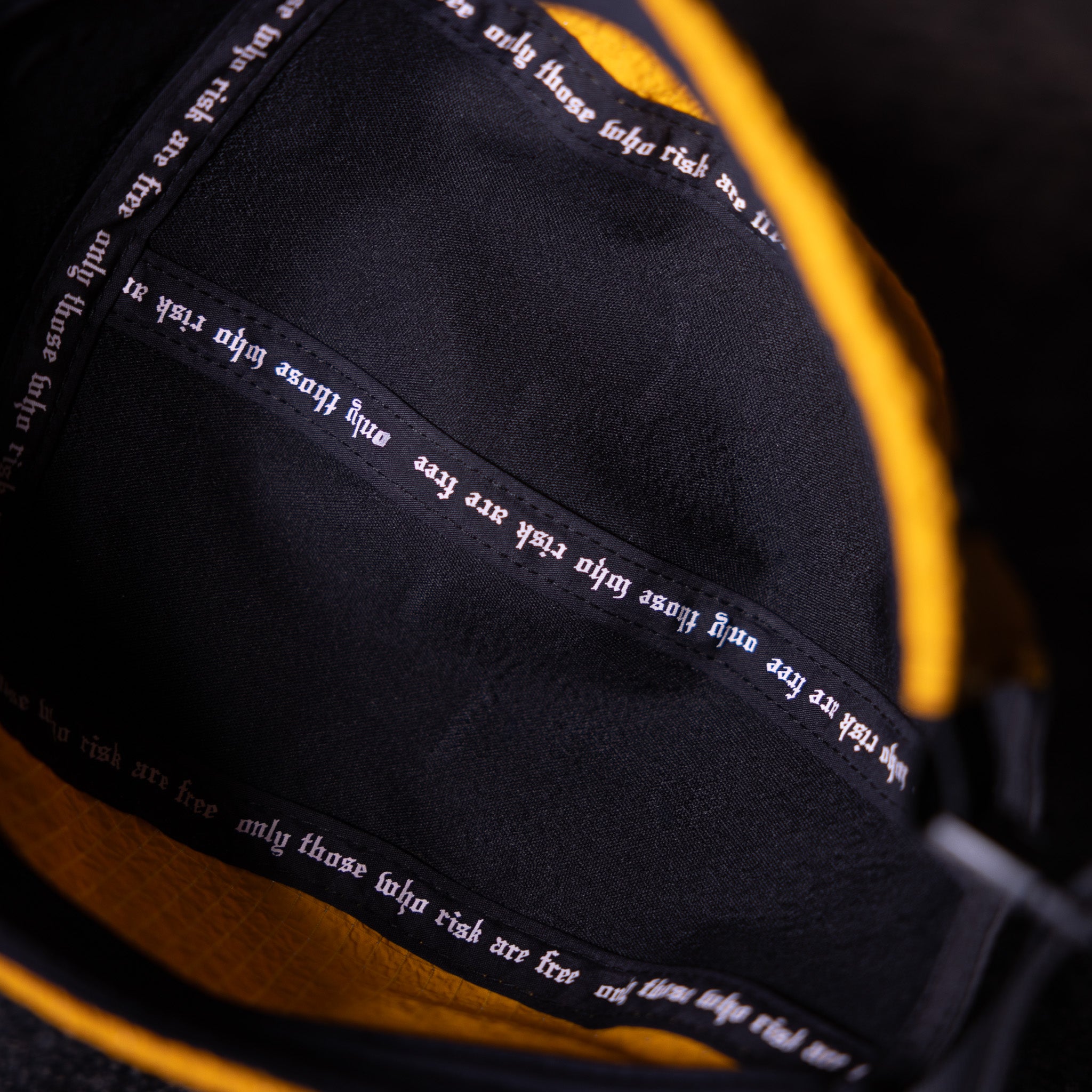 WN'23 Two Tone 5 Panel Hat in black and gold, detail closeup of text on brim