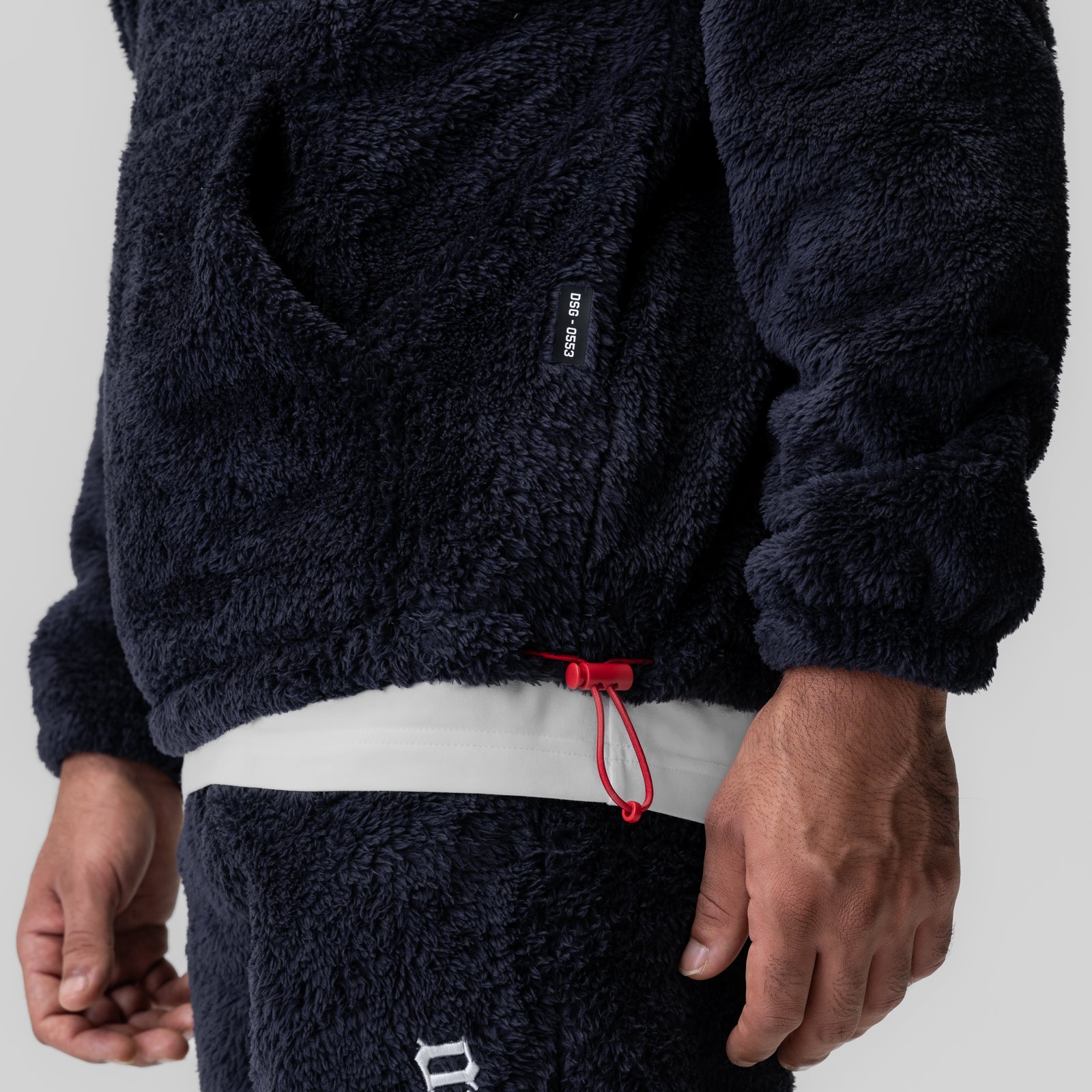 Sherpa Recovery Hoodie in navy worn by model, showing waistband detail with red drawstring