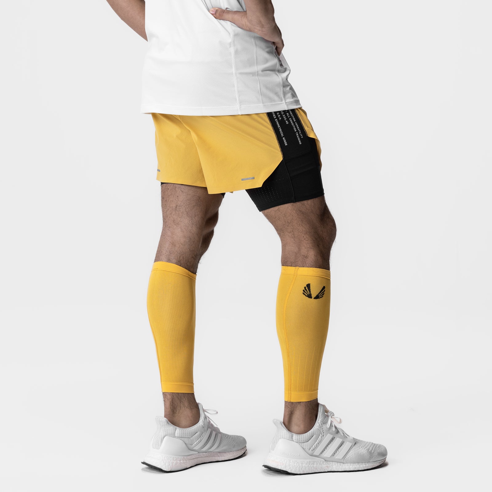 Body-Mapped Calf Sleeve in amber yellow worn on model's legs with matching shorts