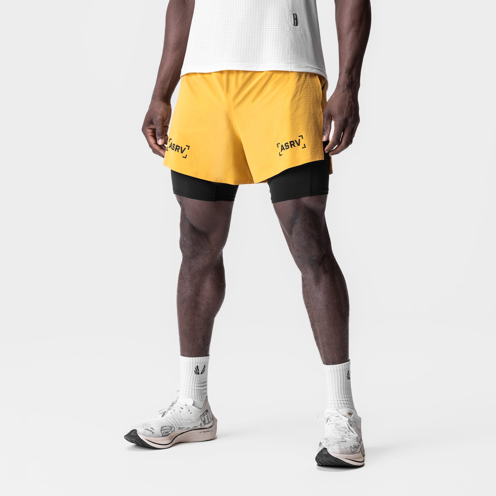 Aerotex 4" High Split Liner Short in amber yellow with black liner, modeled with white socks and sneakers