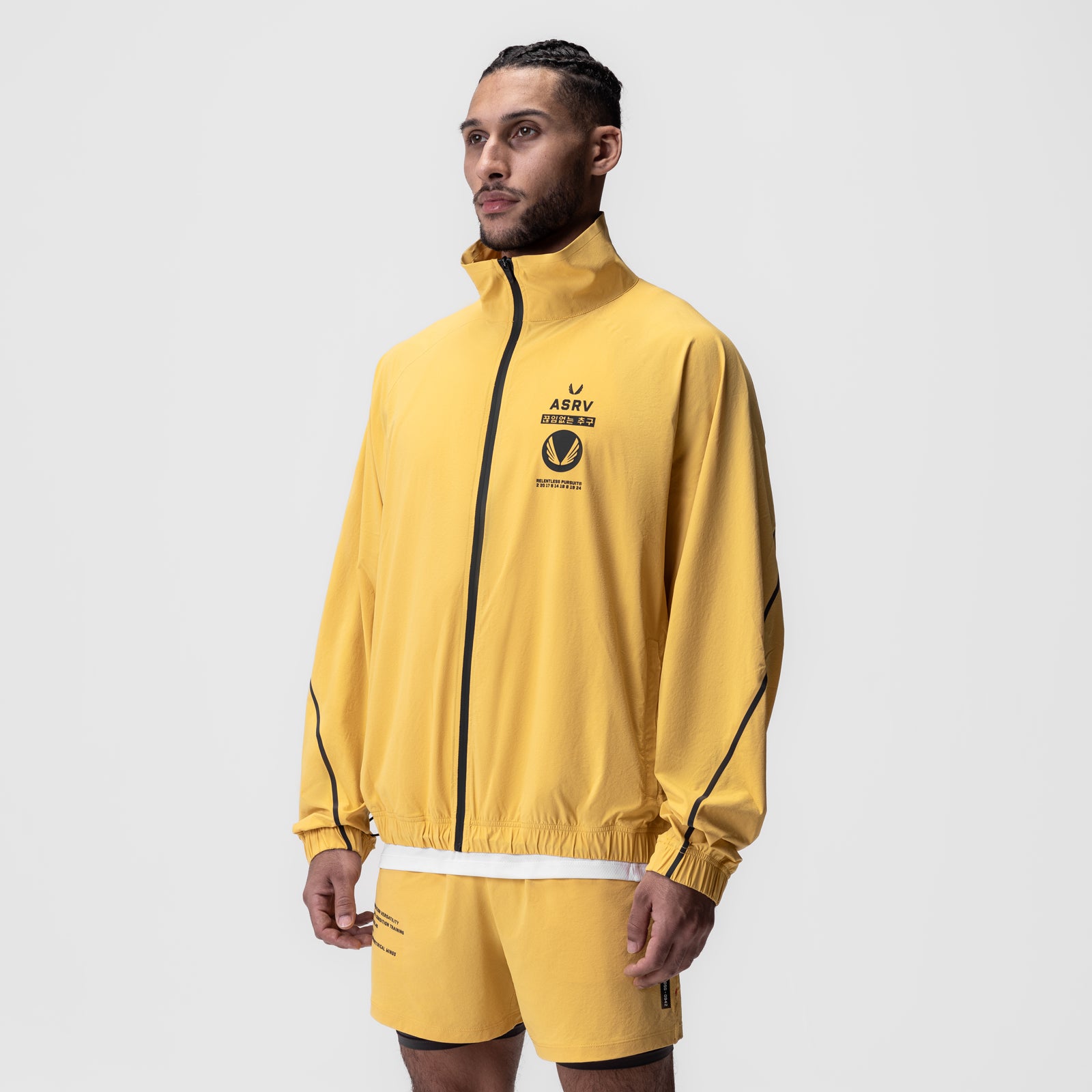 Aerotex Track Jacket in amber yellow with black trim, worn by model in three-quarter view