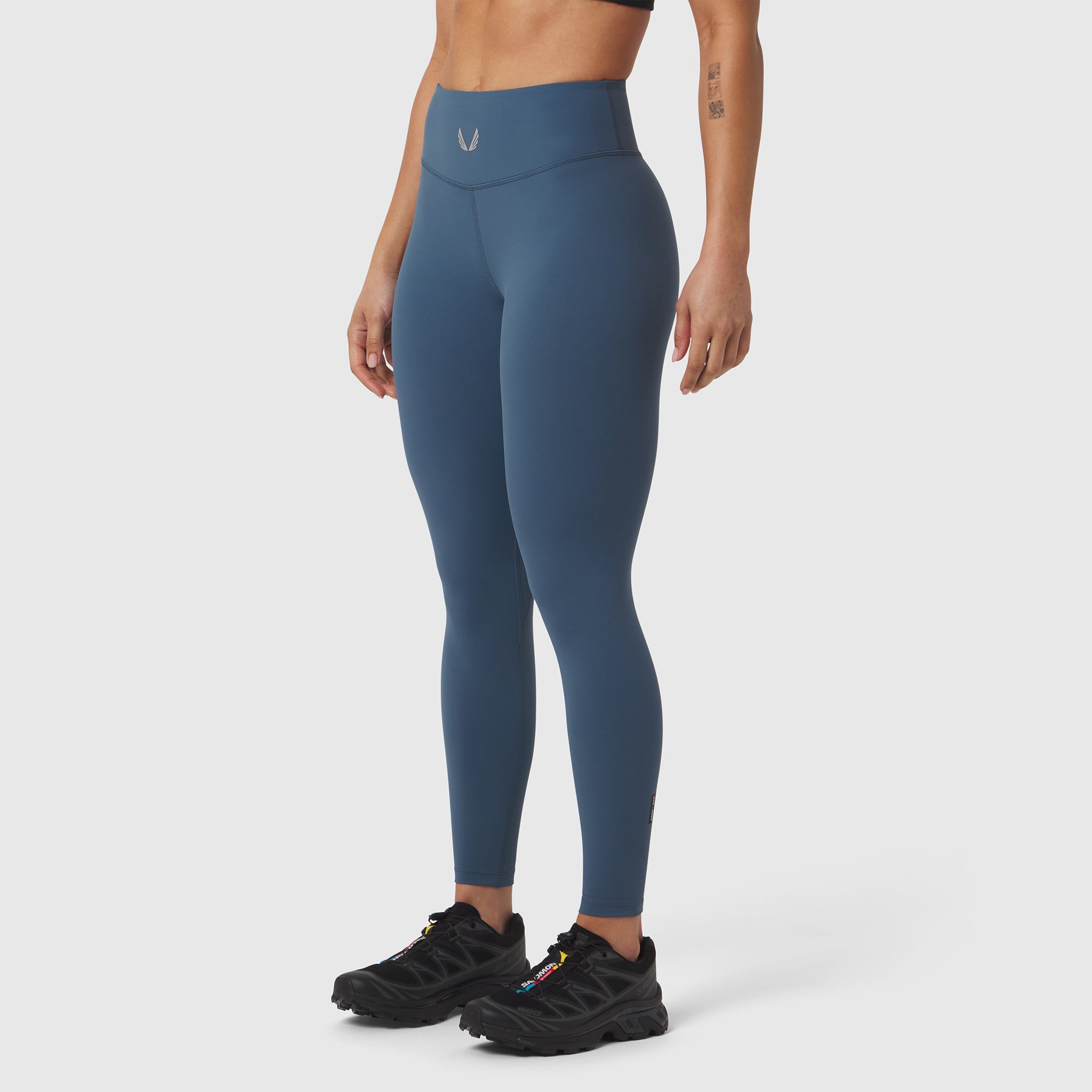W002 LYCRA® ADAPTIV Legging in storm blue, worn by model with black sneakers