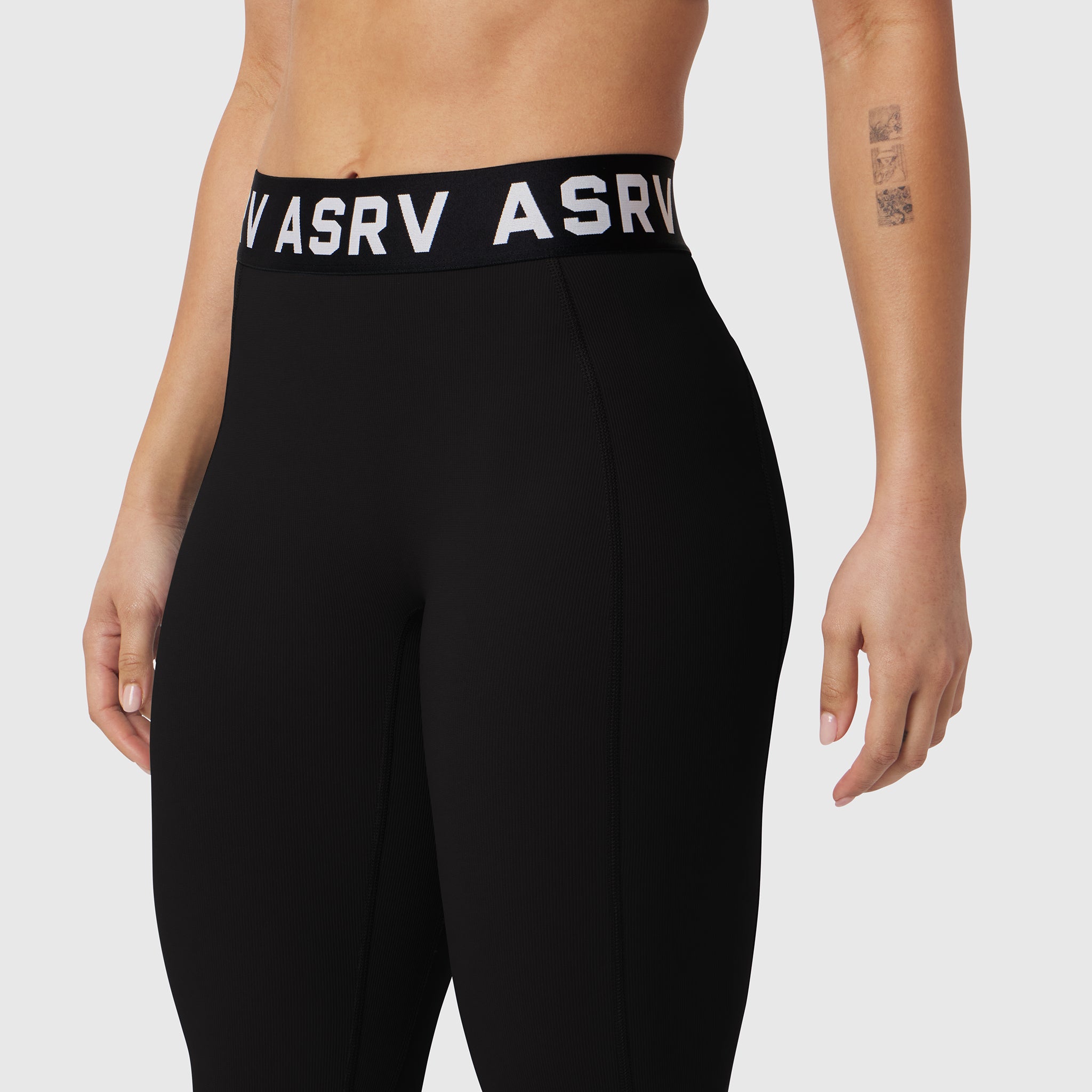 Black LYCRA® ribbed legging with branded waistband, worn by model, front view