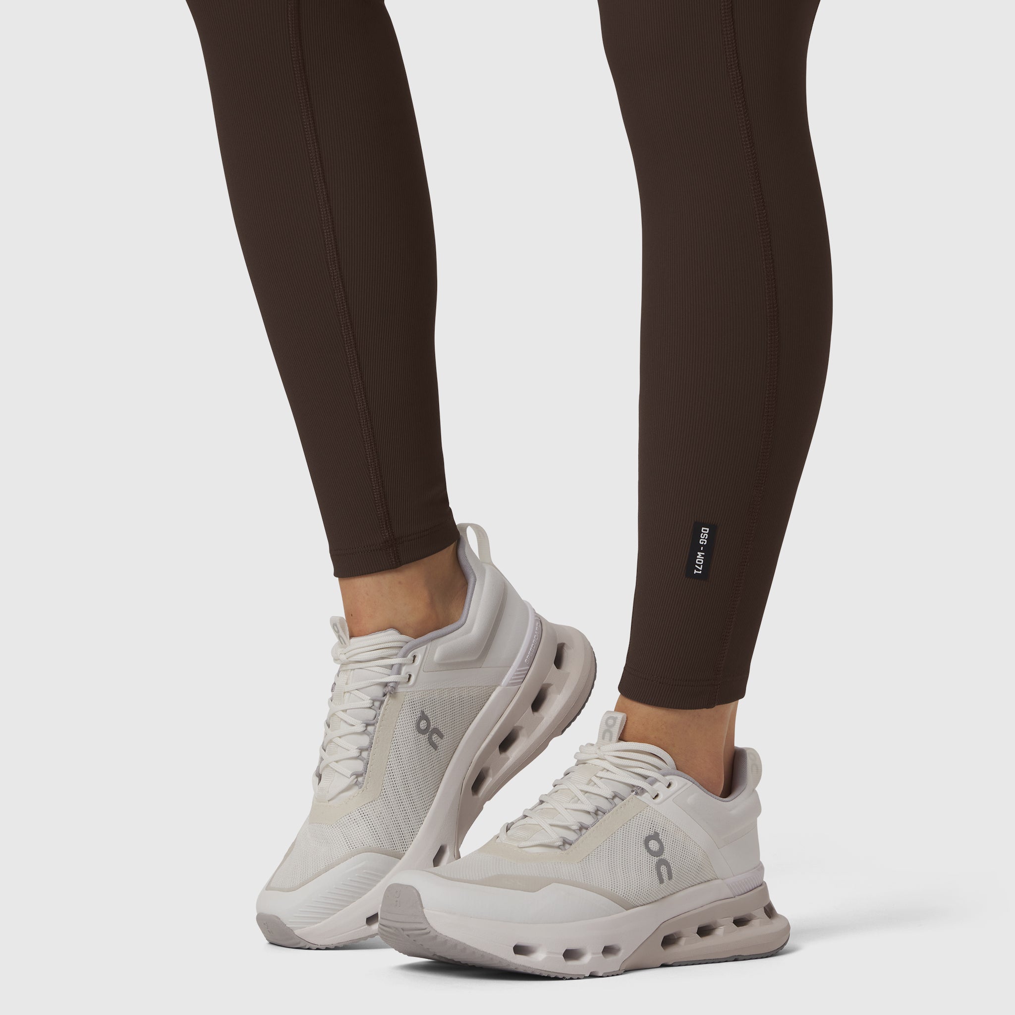 W071 LYCRA® Ribbed Legging in Dark Earth, worn with white sneakers, front view