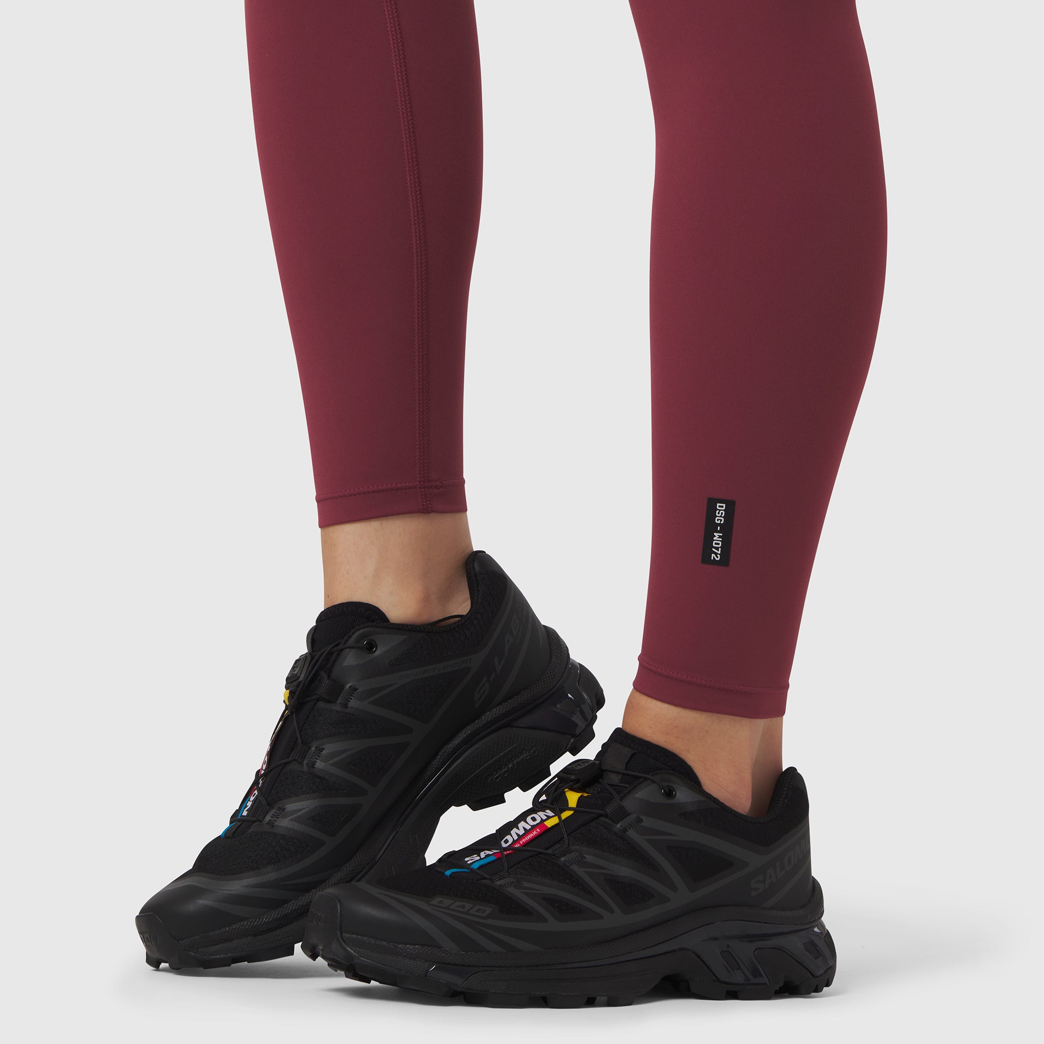 W072 LYCRA® ADAPTIV 4 Pocket Legging in crimson, worn with black sneakers, legs visible