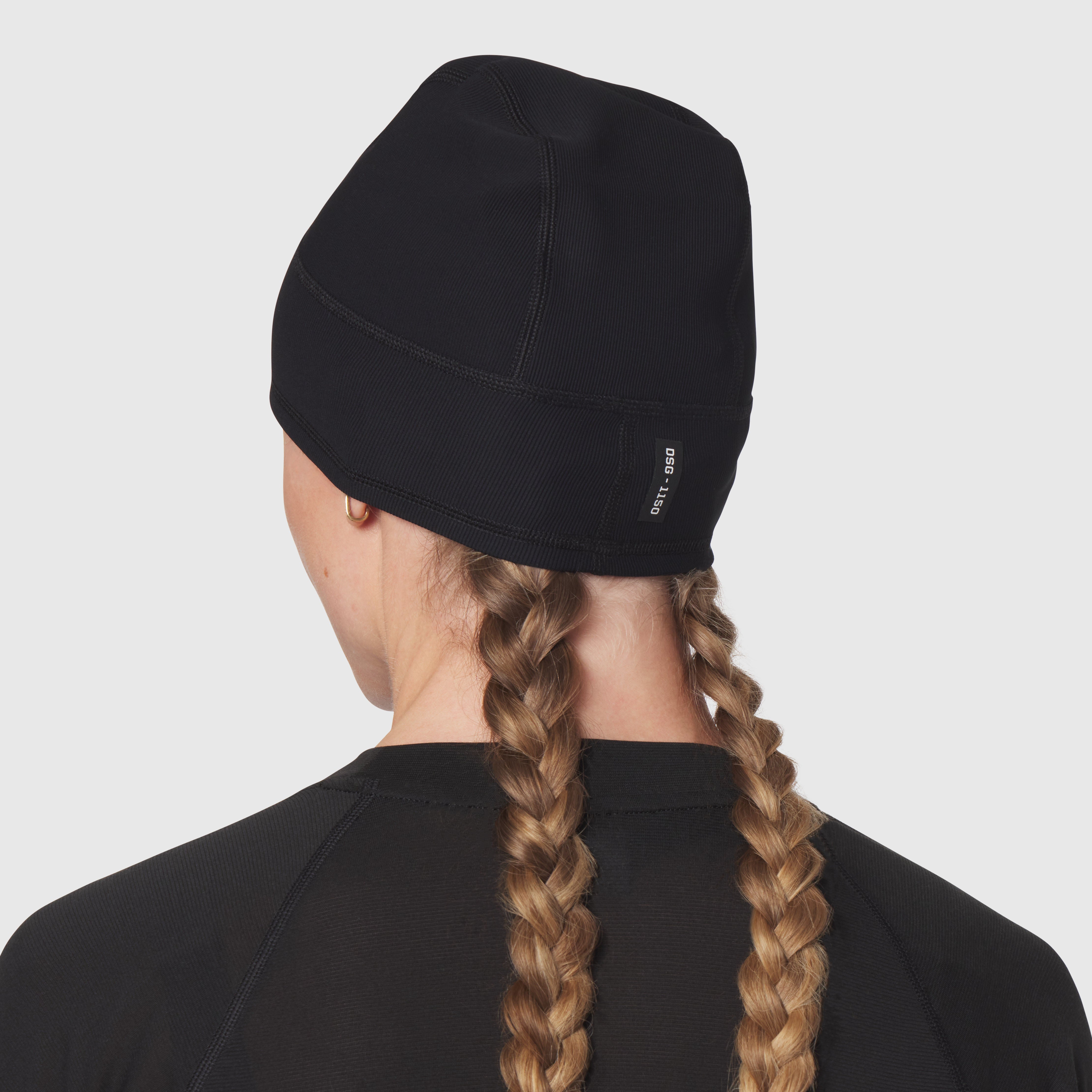 Black Lycra Skully beanie worn by model from back view, showing braided hair detail