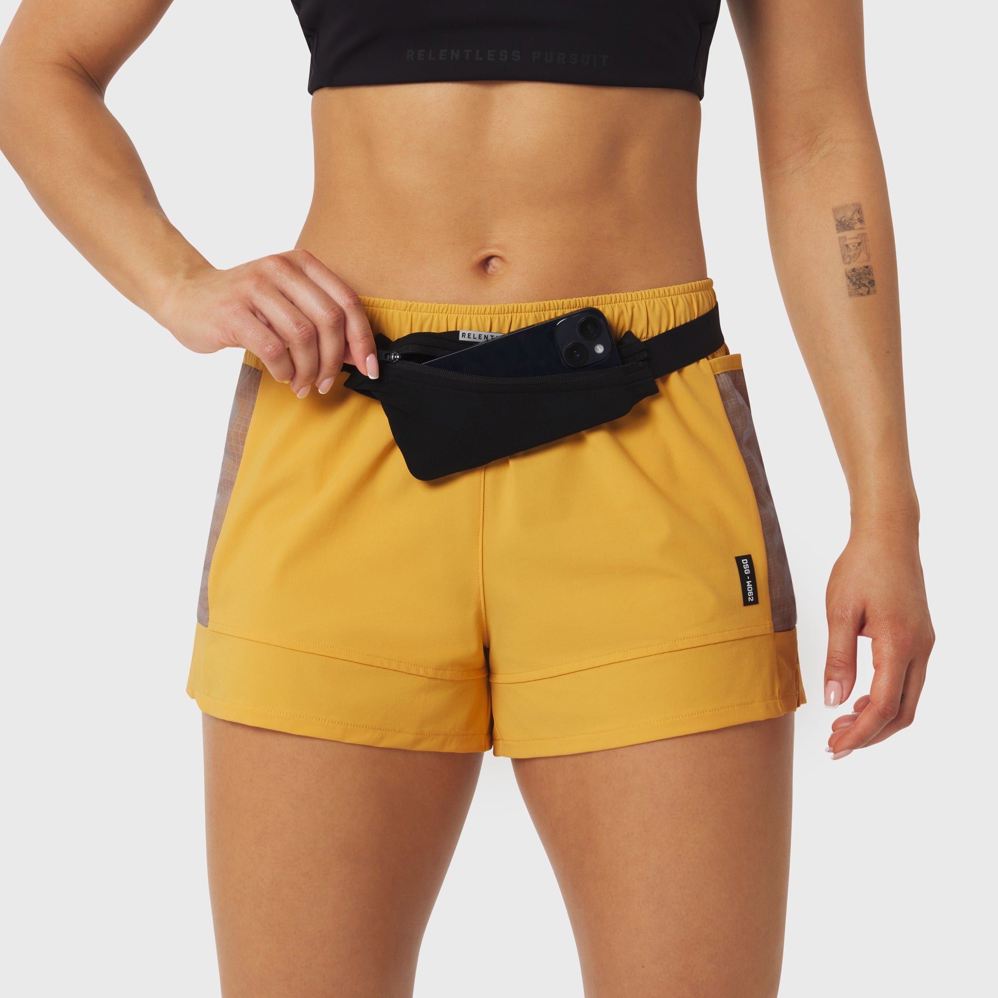Black Expandable Belt Pack worn on yellow shorts, front view