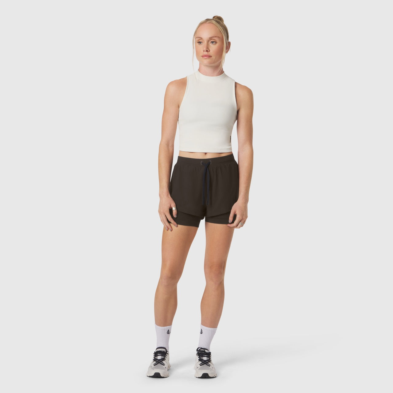 Ivory cream ribbed mockneck tank worn with black shorts, front view on model