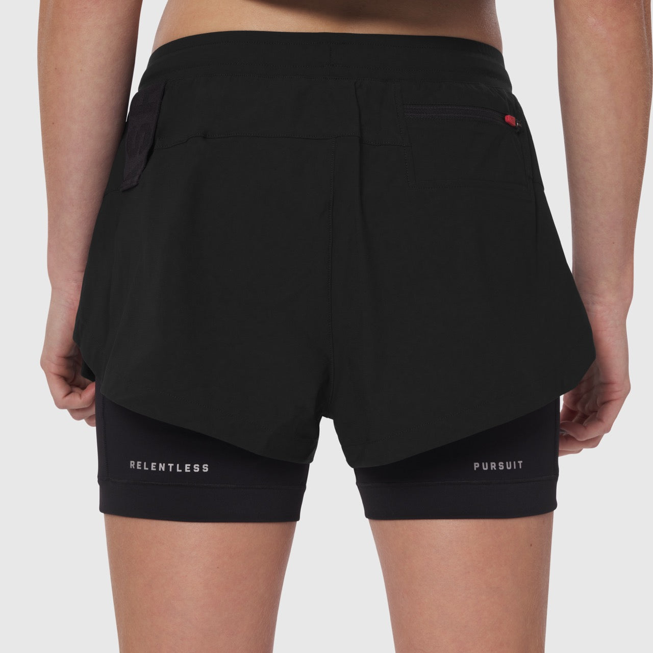Tetra-Lite Liner Short in black, rear view on model showing layered design with 'Relentless Pursuit' text