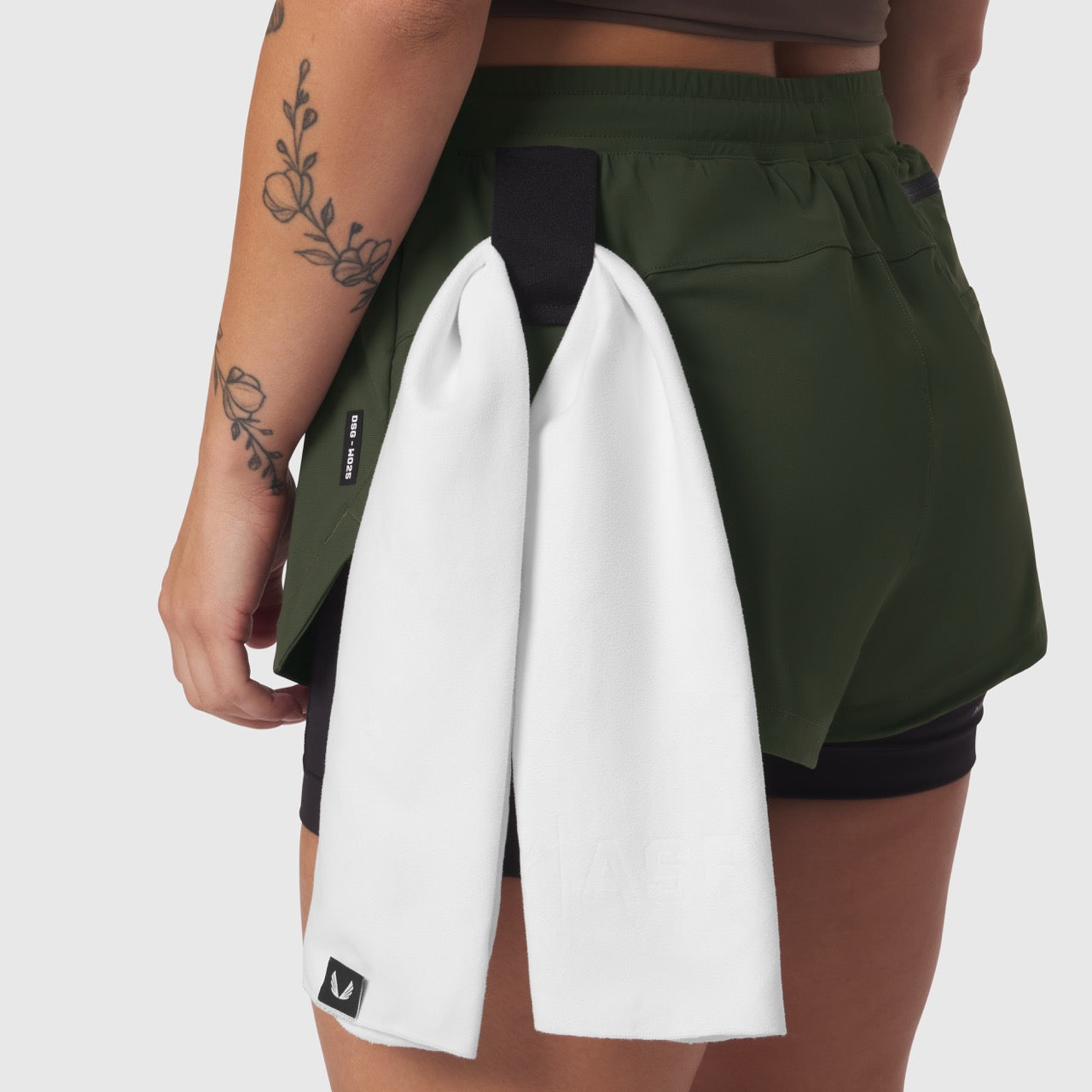 Tetra-Lite® Liner Short in olive worn by model, back view with white towel