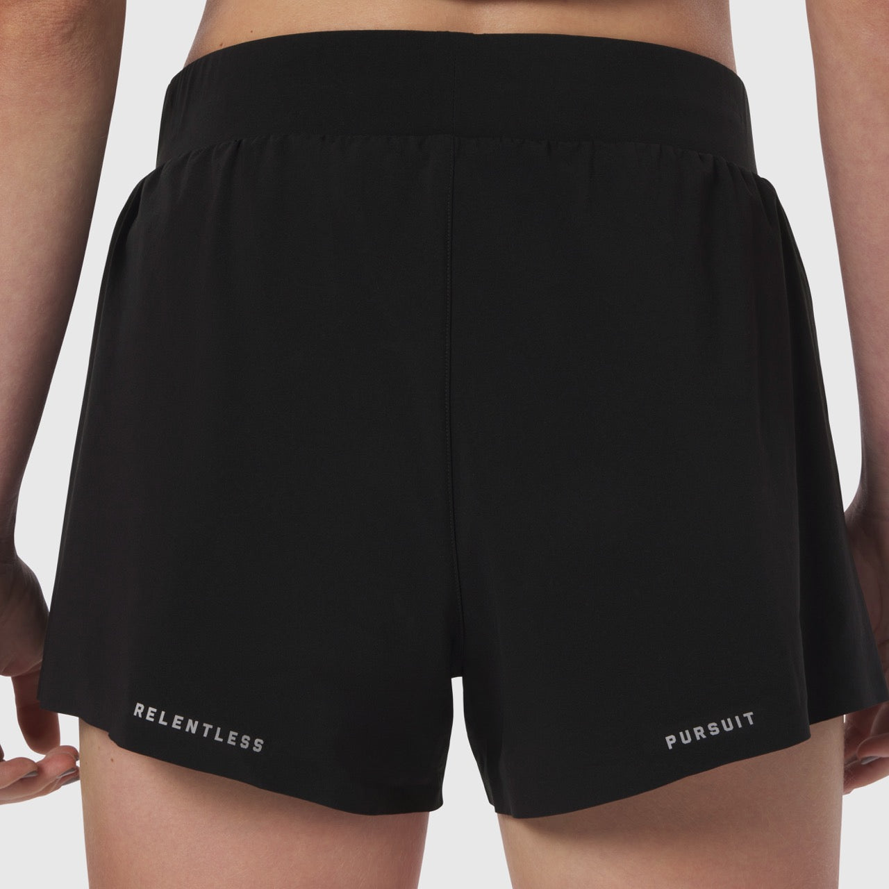 Black Aerotex Side Split Run Short worn by model, back view showing 'Relentless Pursuit' text