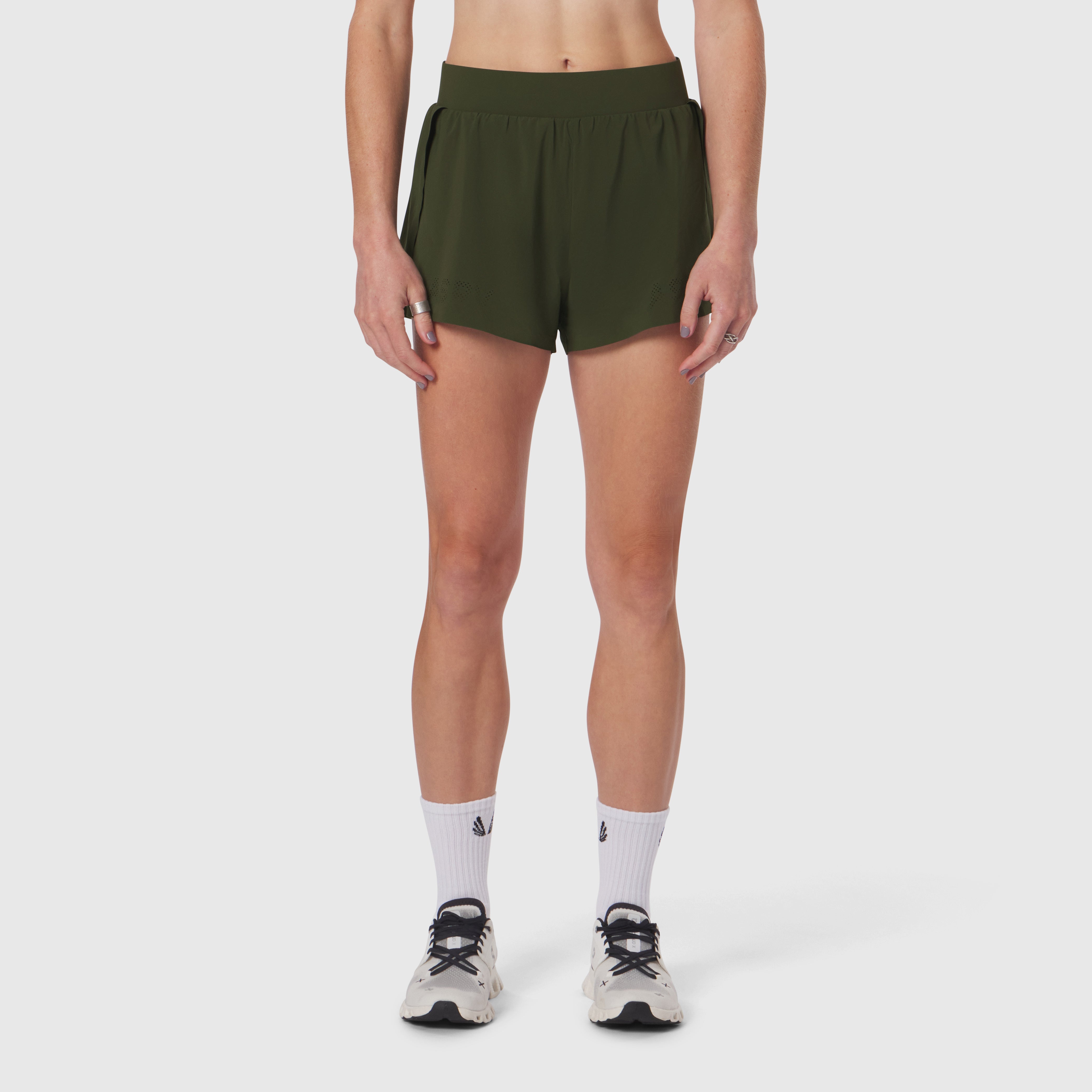 Aerotex Side Split Run Short in olive, modeled on woman with white socks and running shoes