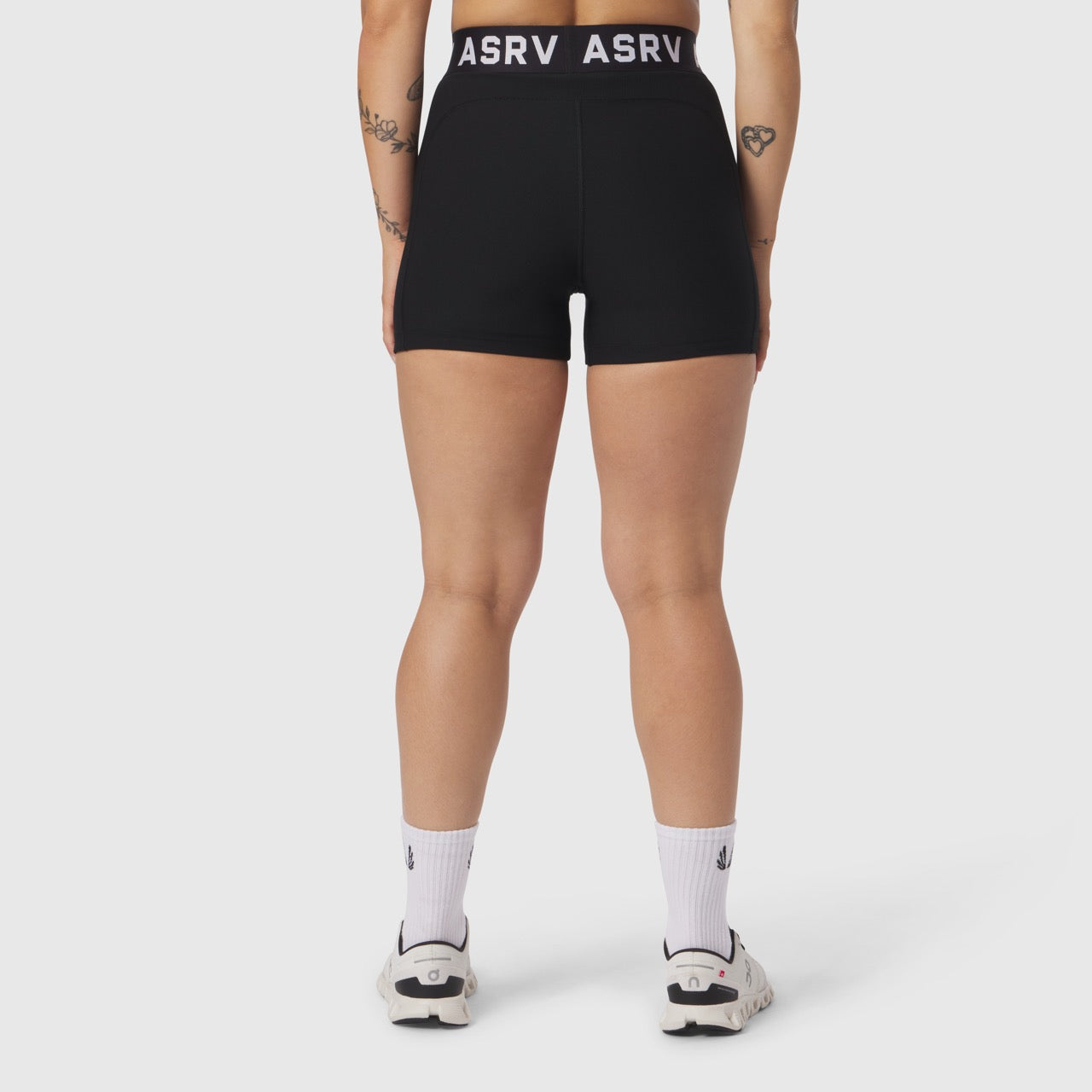 W027 Lycra Ribbed Short in black, rear view on model wearing white socks