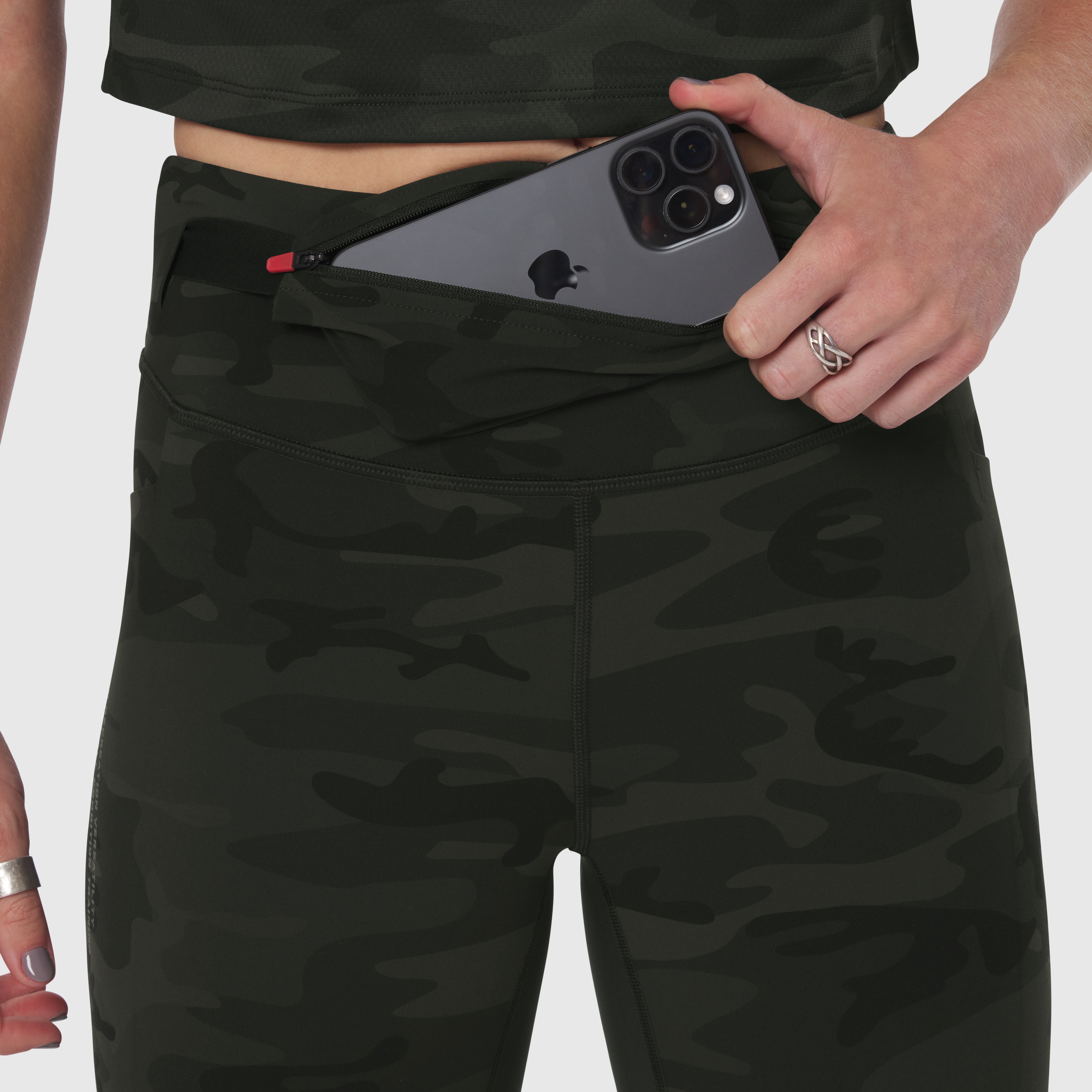 W030 LYCRA® 3-in-1 Legging in Dark Camo with model holding phone in waistband pocket