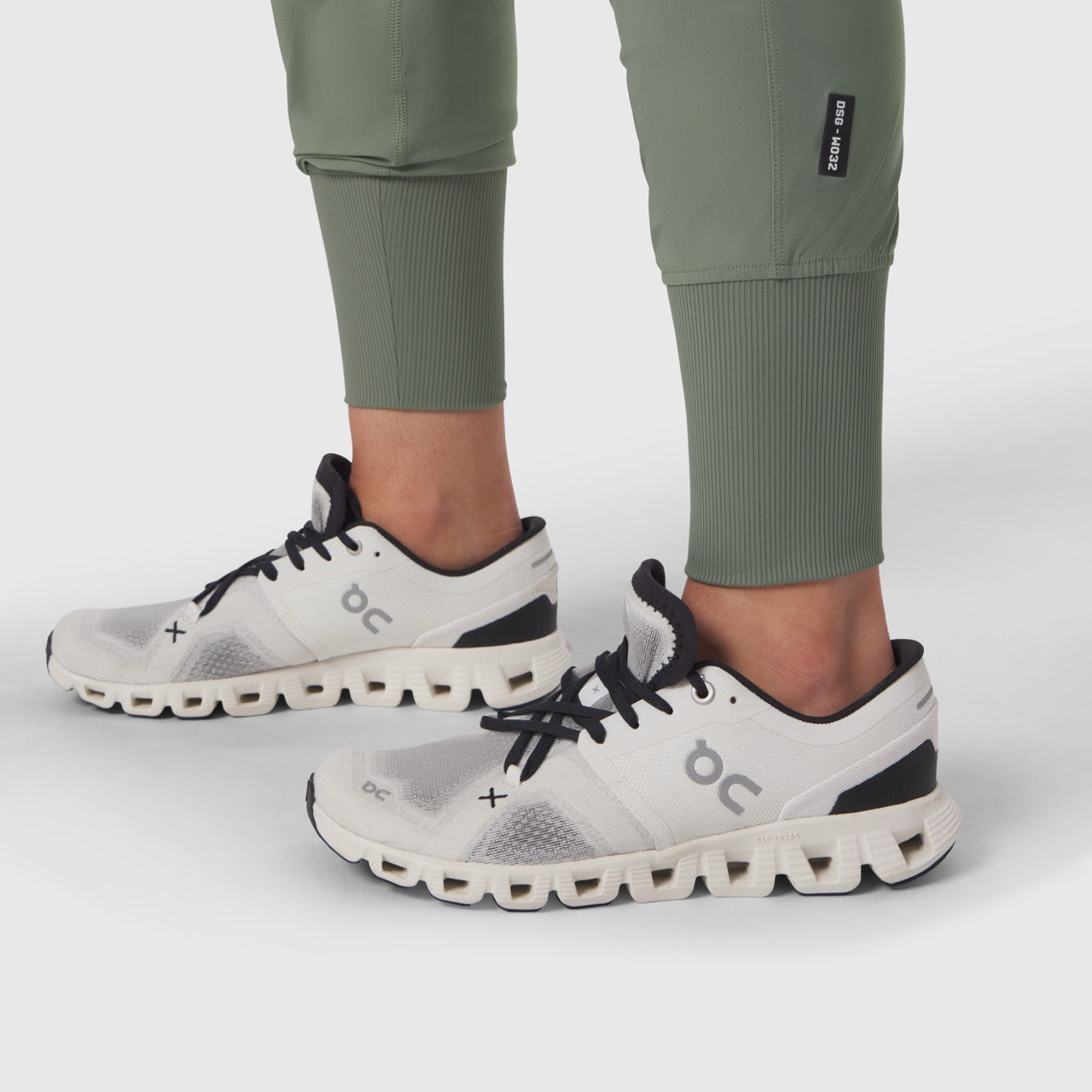 W032 Tetra-Lite Cargo High Rib Jogger in sage worn with white running sneakers, front view