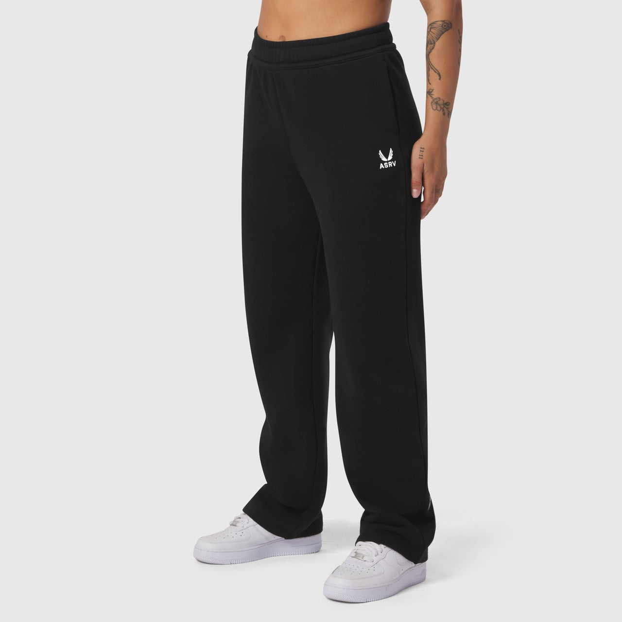 Black Sorona® Terry straight leg sweats worn by model with white sneakers, front view