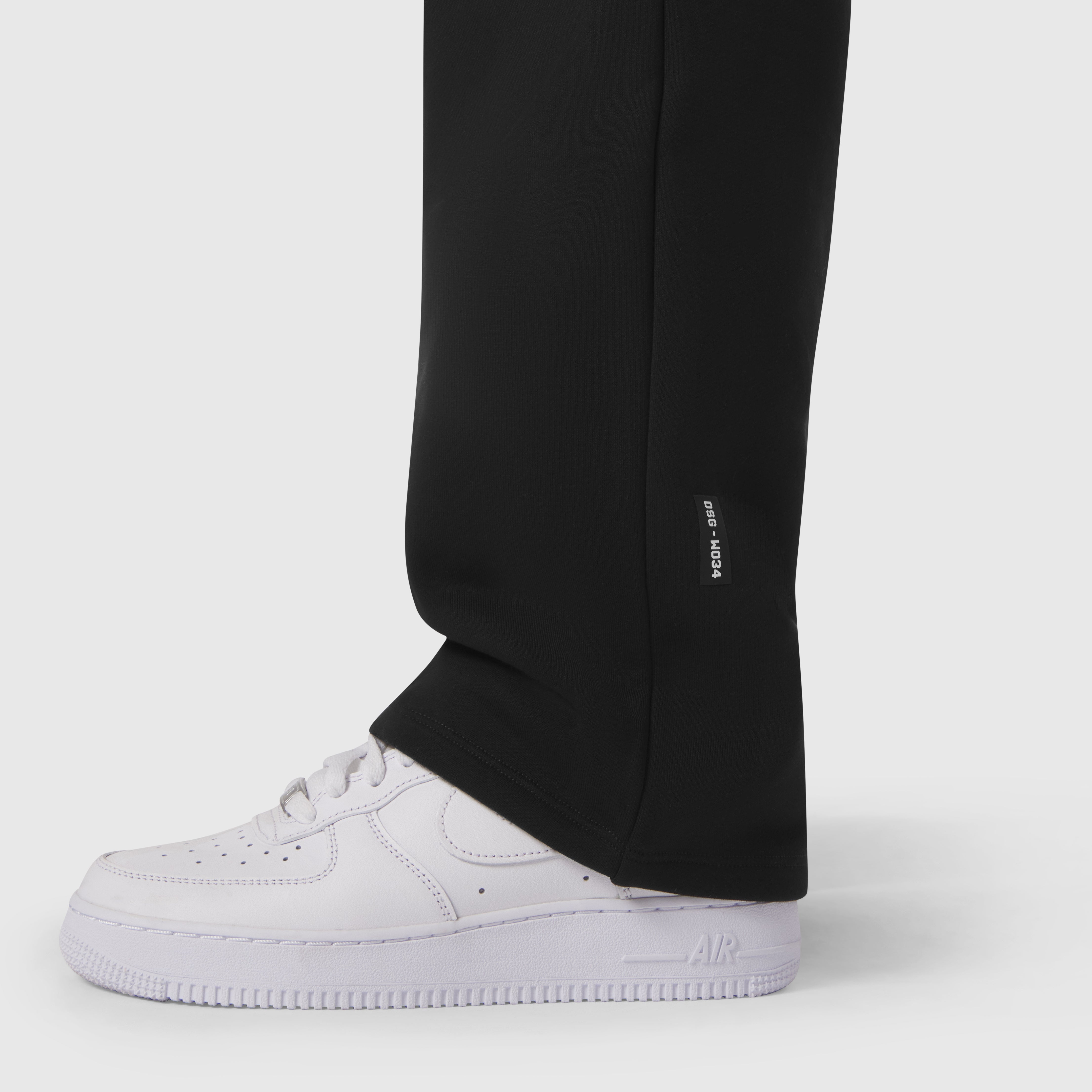 Black Sorona® Terry straight leg sweats worn with white sneakers, cropped leg view