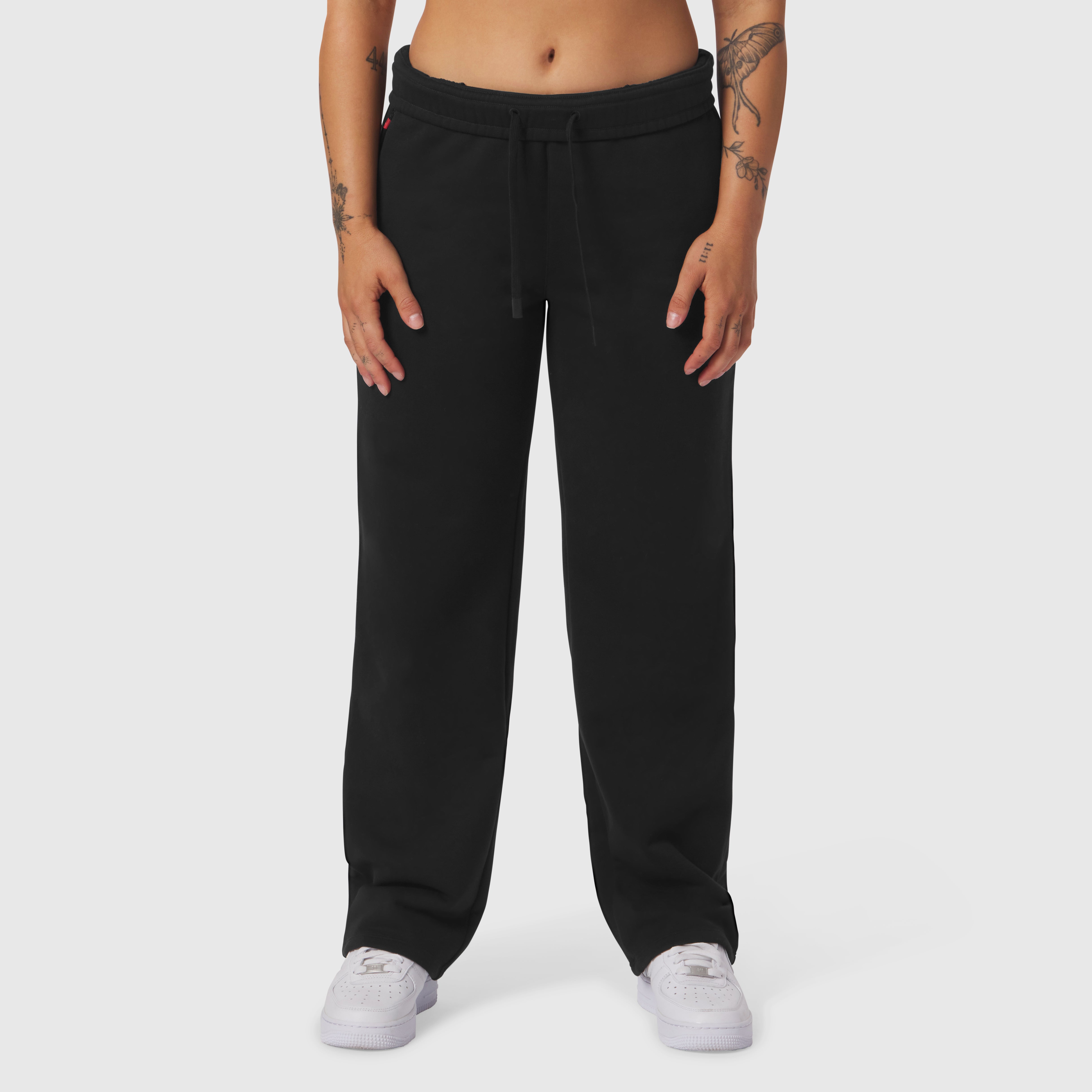 Black Sorona® Terry straight leg sweats on model, front view with white sneakers