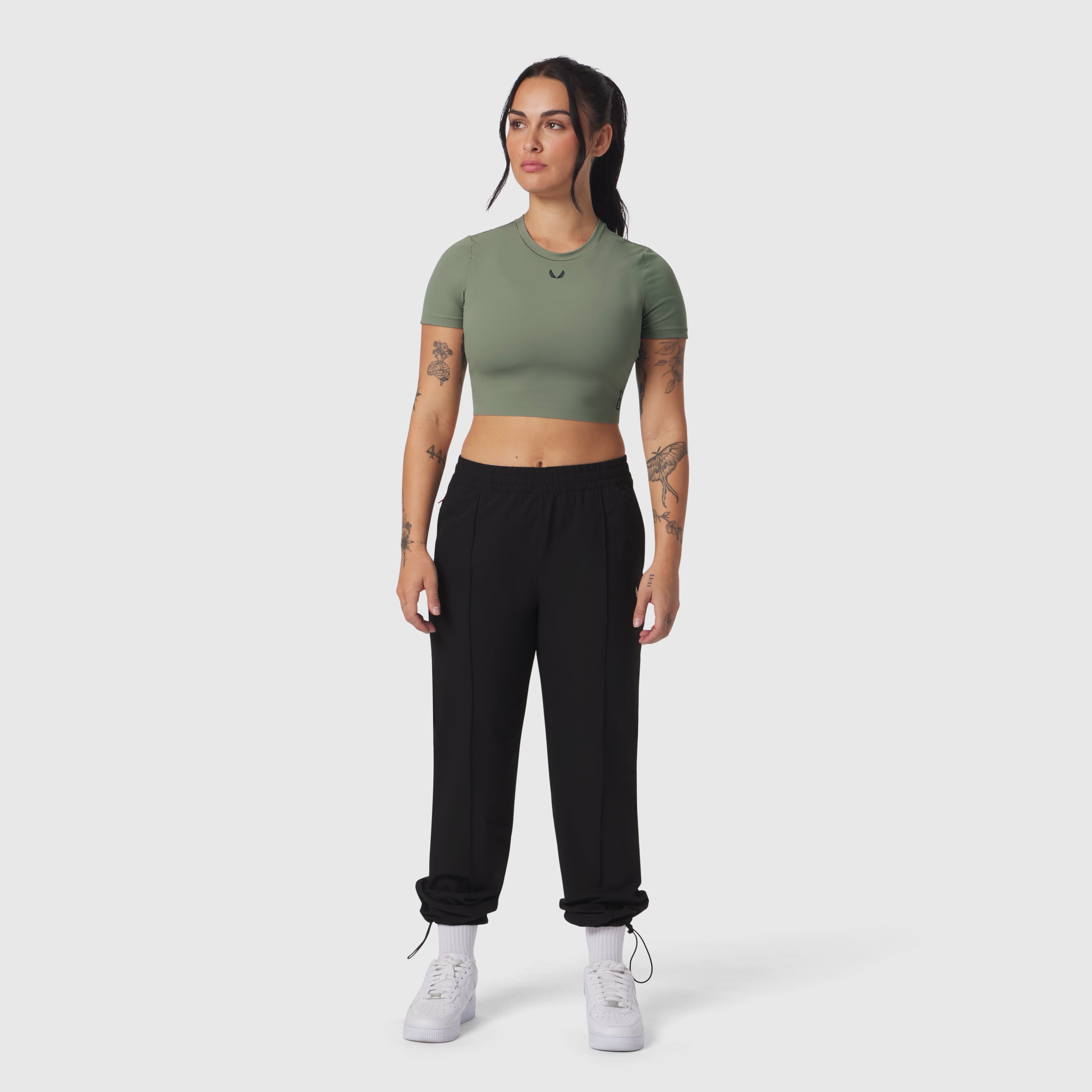 Black Ripstop Relaxed Track Pant worn with sage green crop tee and white sneakers, front view
