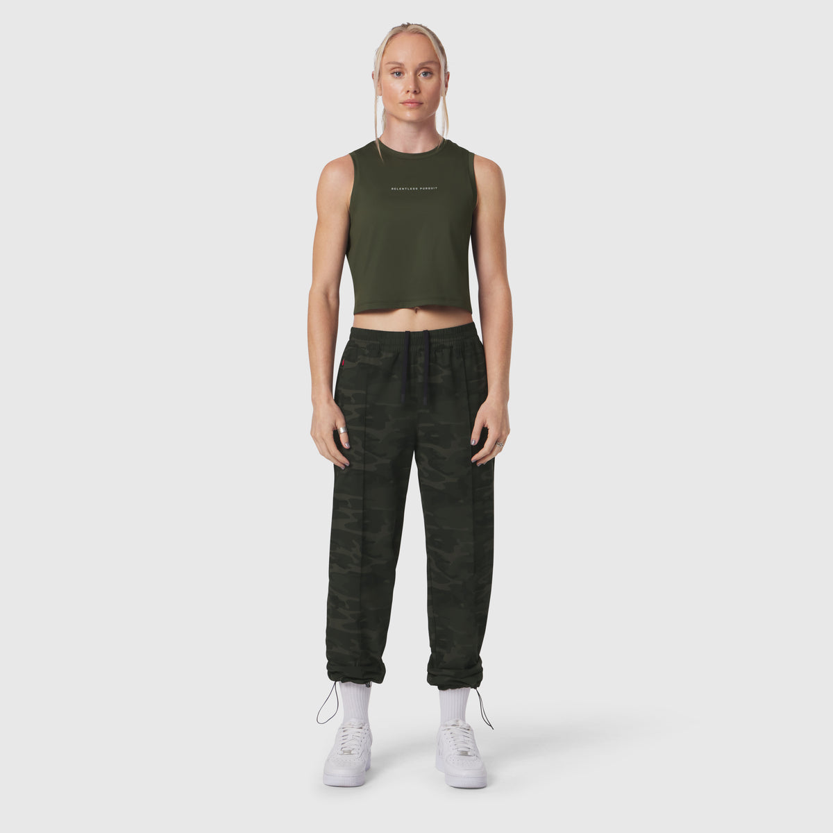 W036 Ripstop Relaxed Track Pant in dark camo, worn with olive crop tank top and white sneakers