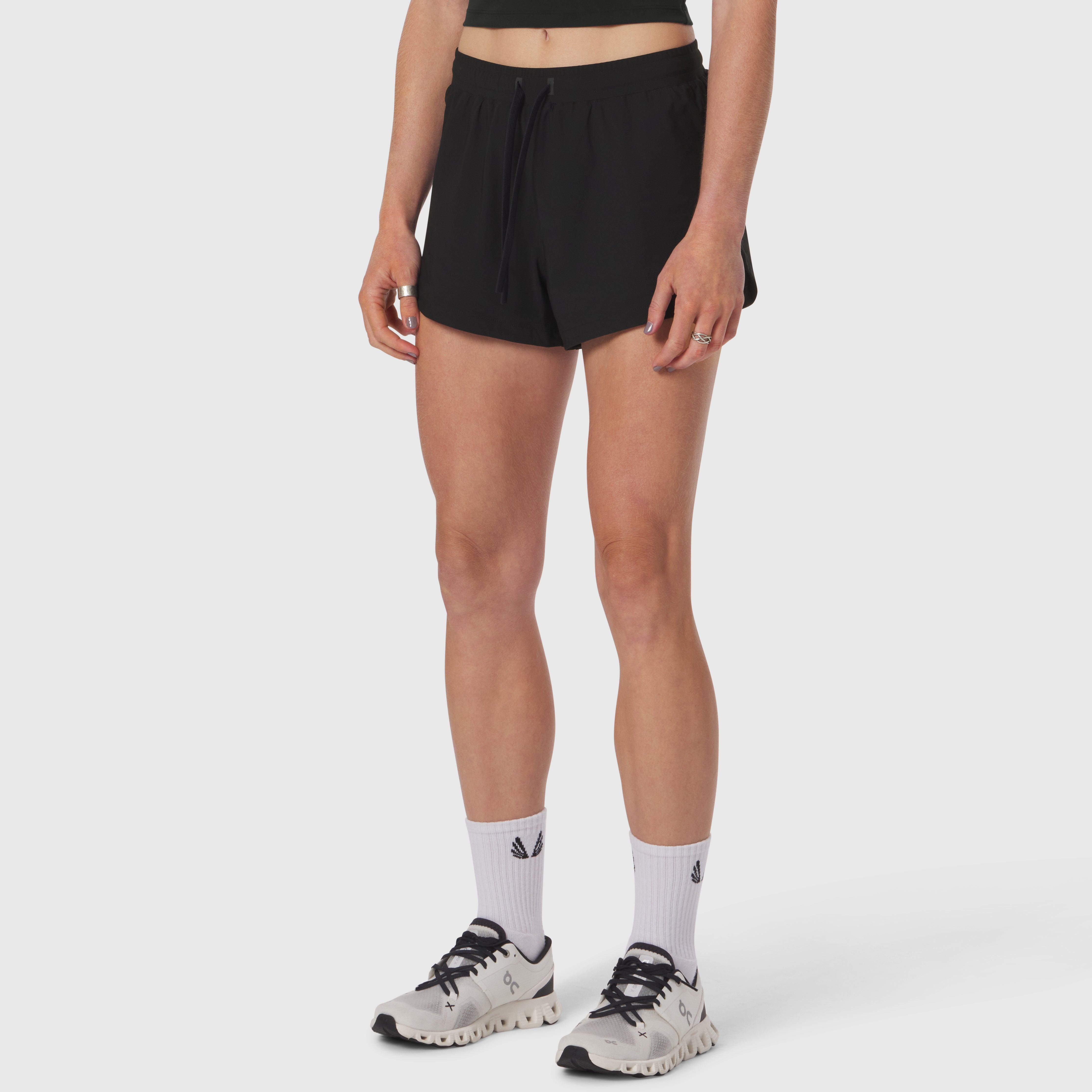 Black Tetra-Lite Linerless shorts worn with white socks and cream running shoes, front view