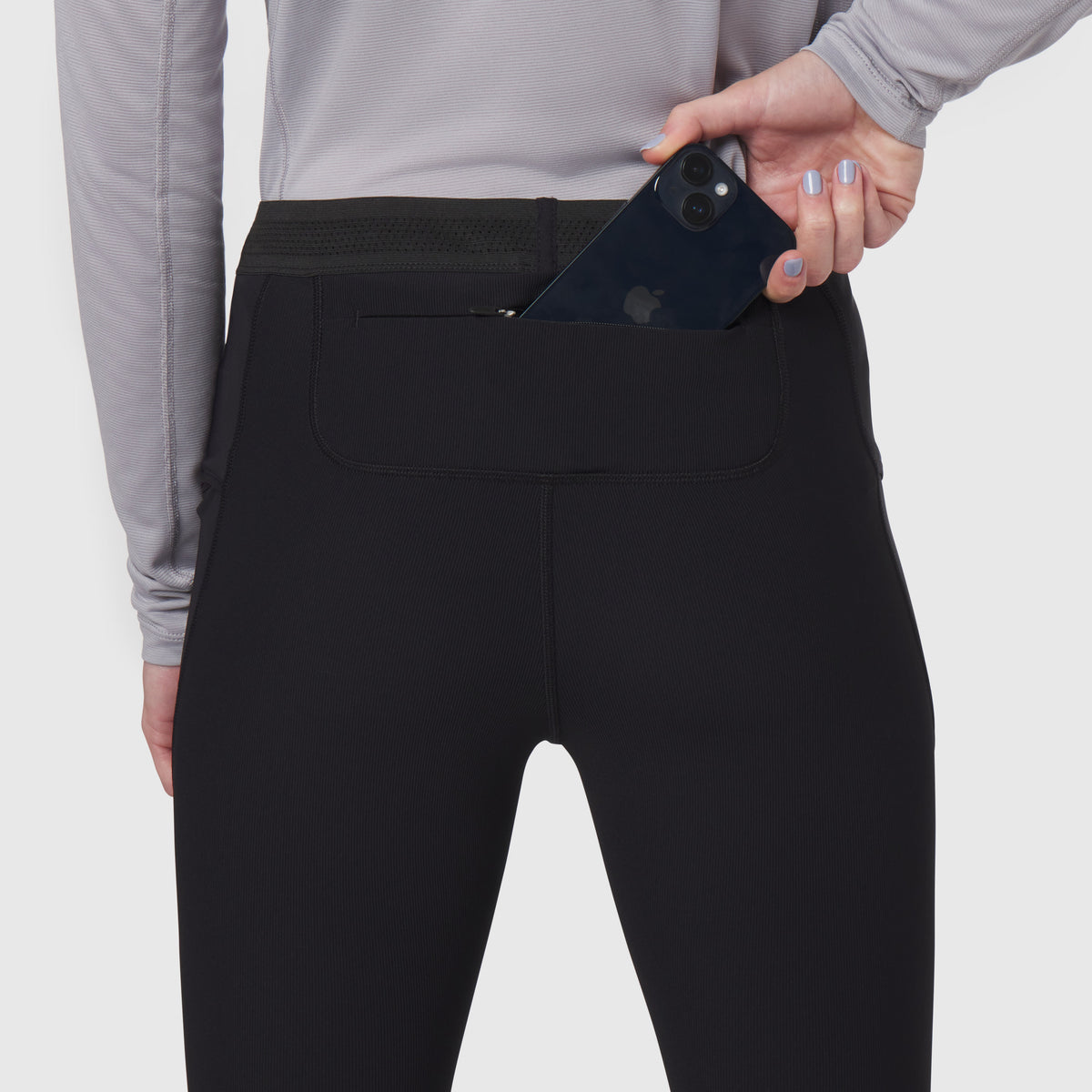 Black Lycra ribbed running tight worn by model, demonstrating phone pocket detail
