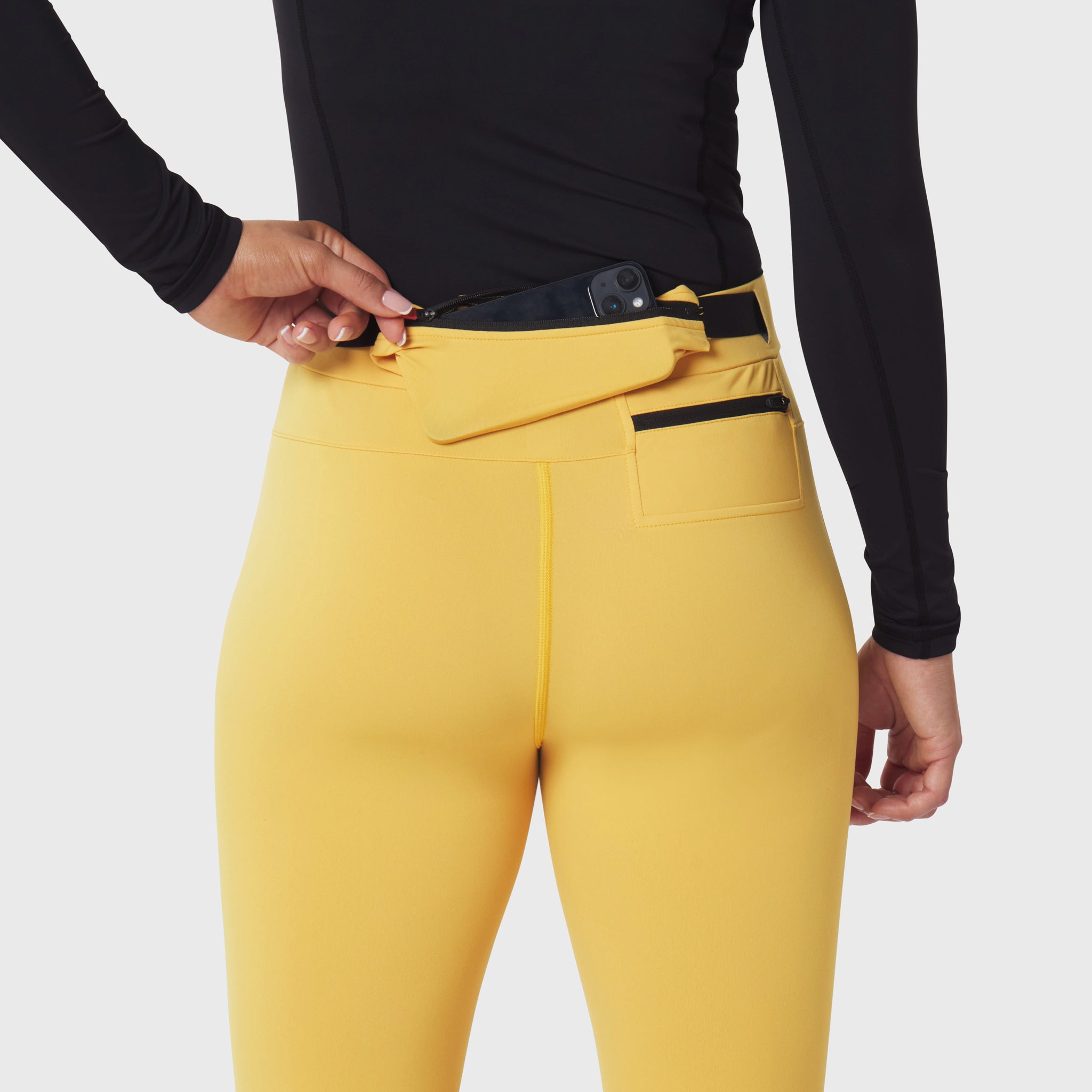W059 Hybrid Belt-Pack Run Legging in amber, worn by model showing waist belt detail