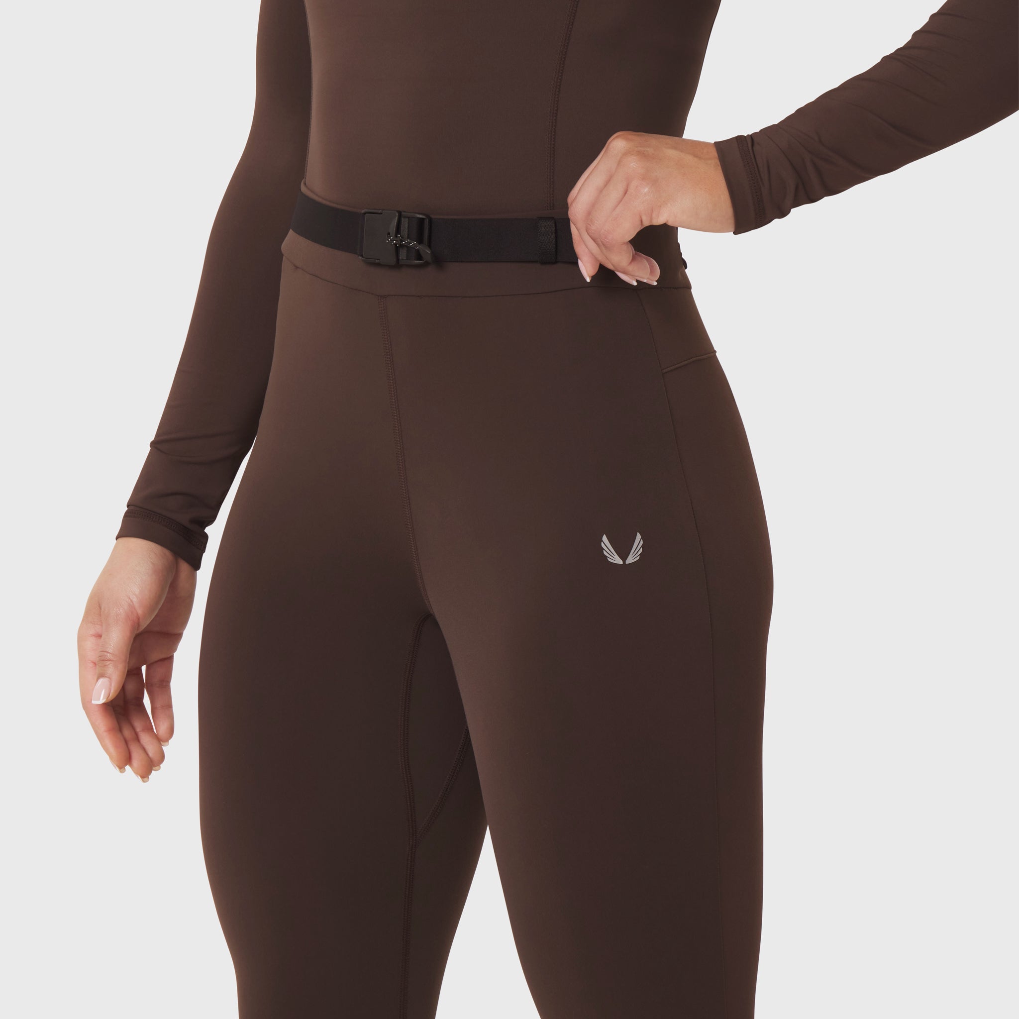 W059 Hybrid Belt-Pack Run Legging in dark earth, worn by model showing waistband and belt detail
