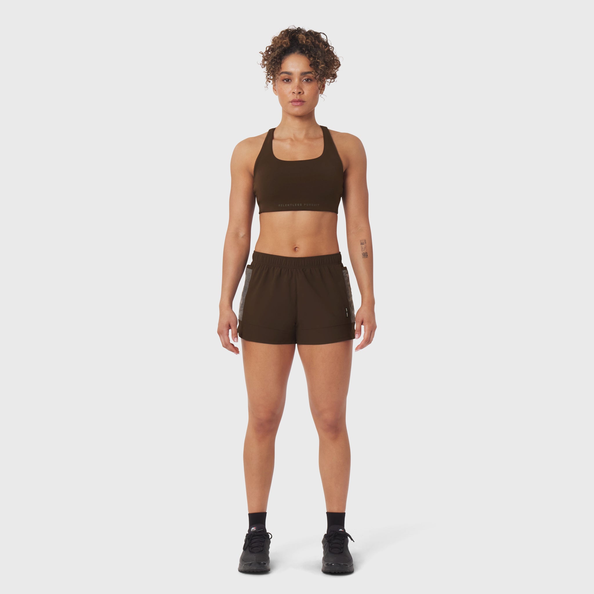 Tetra-Lite Adventure Short in Dark Earth, worn with matching sports bra, front view