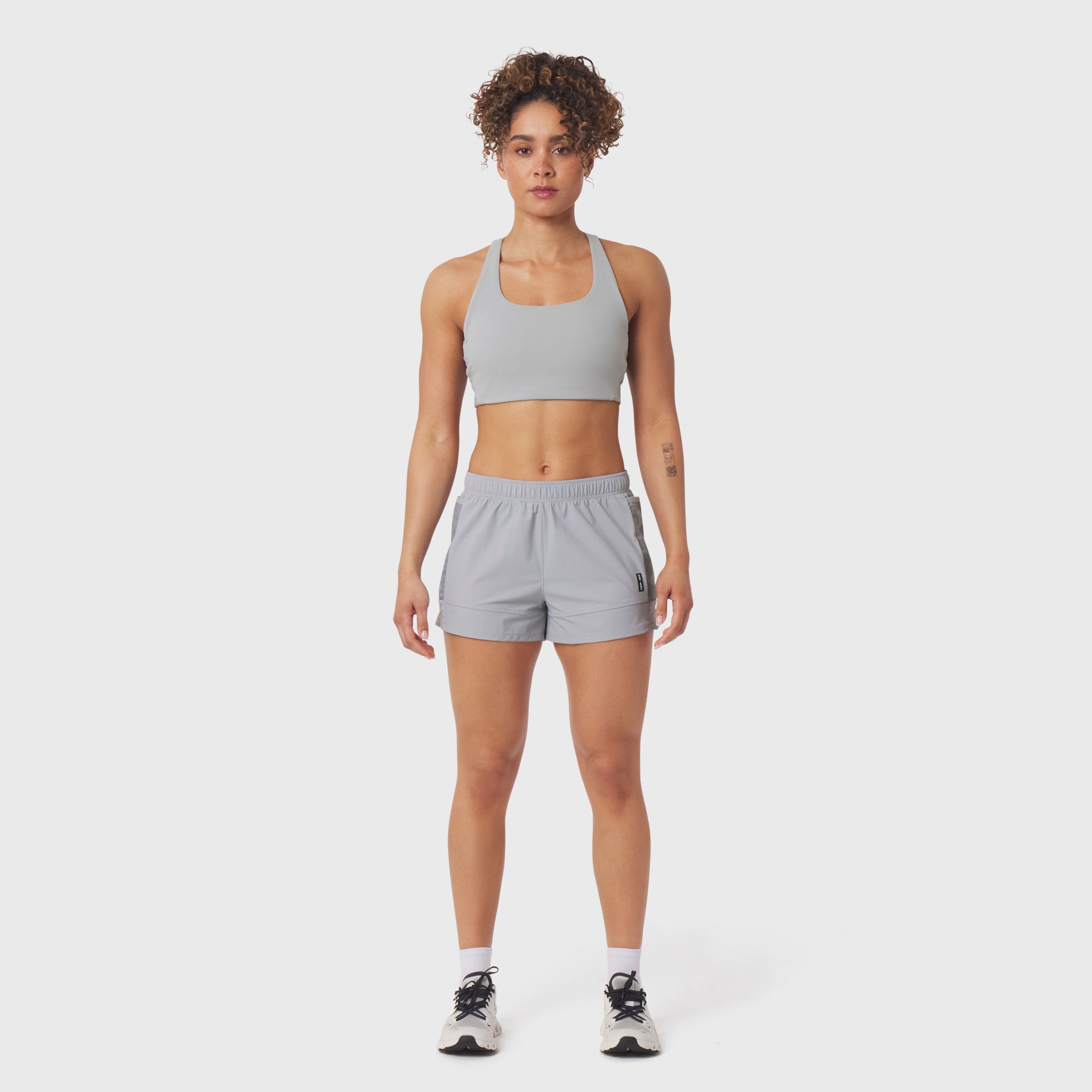 Tetra-Lite Adventure Short in Slate Grey, worn with matching sports bra, front view
