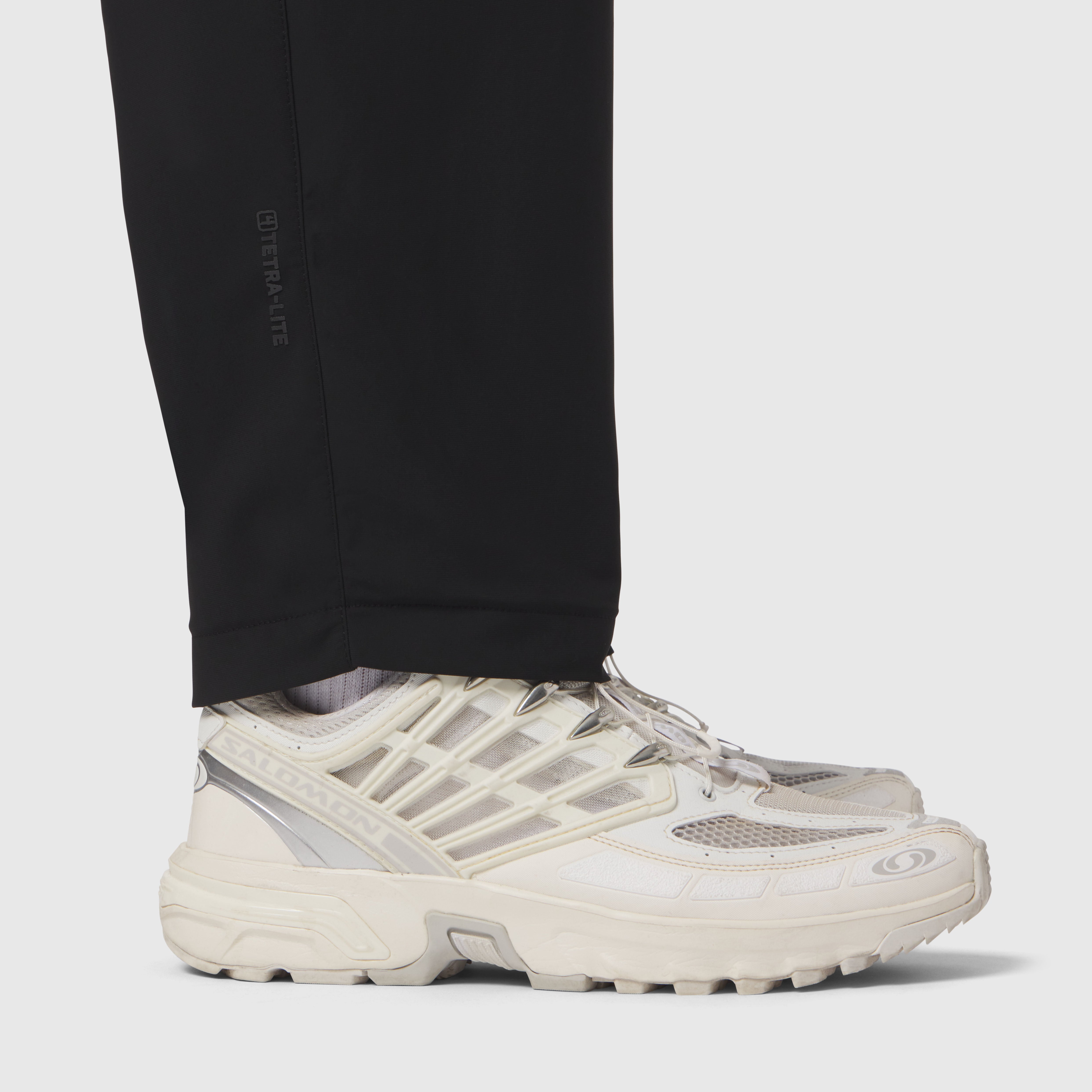 Black Tetra-Lite Cargo City Pant worn with cream sneakers, side view