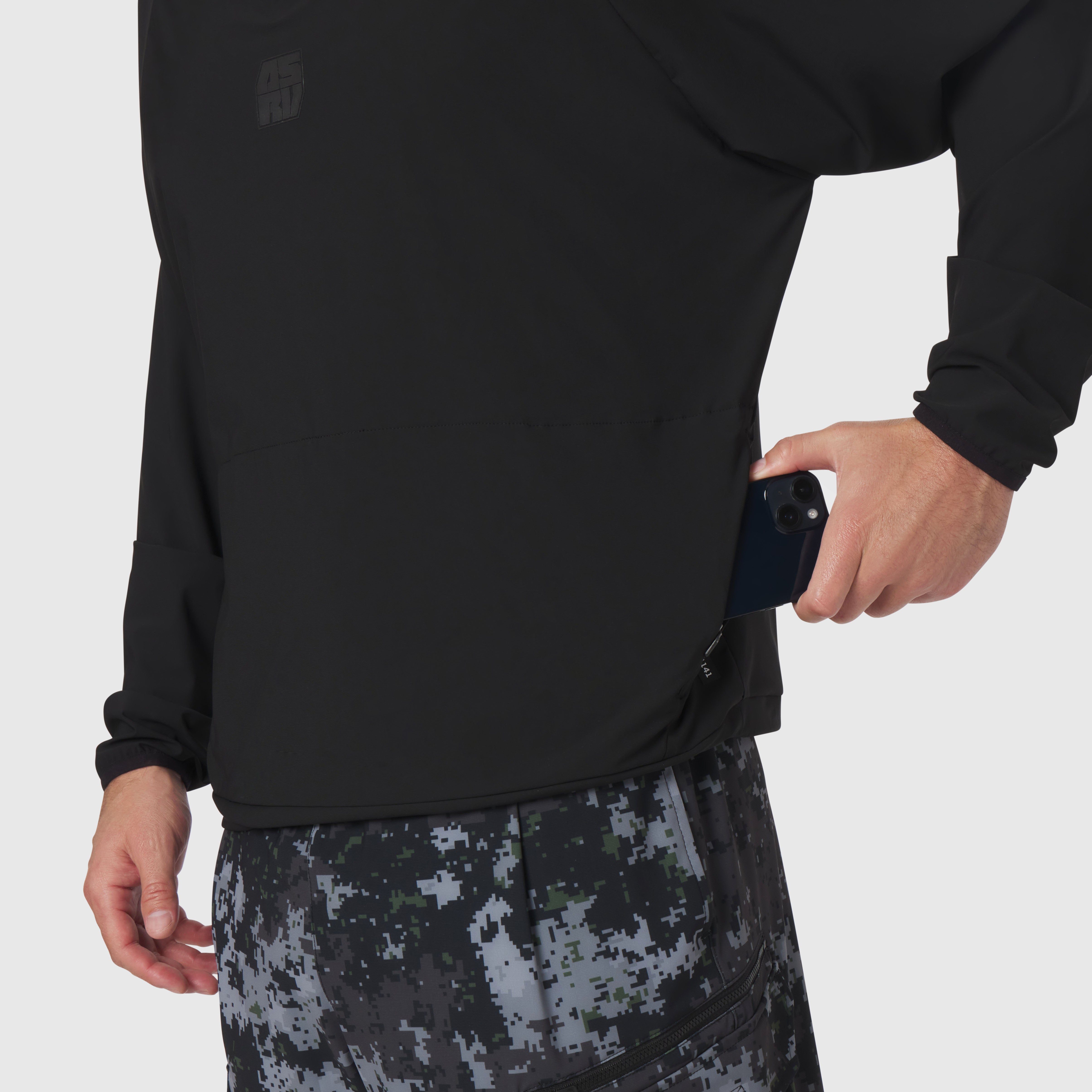 Tetra-Lite® Blade Collar Zip Jacket in black worn by model holding phone, white undershirt visible