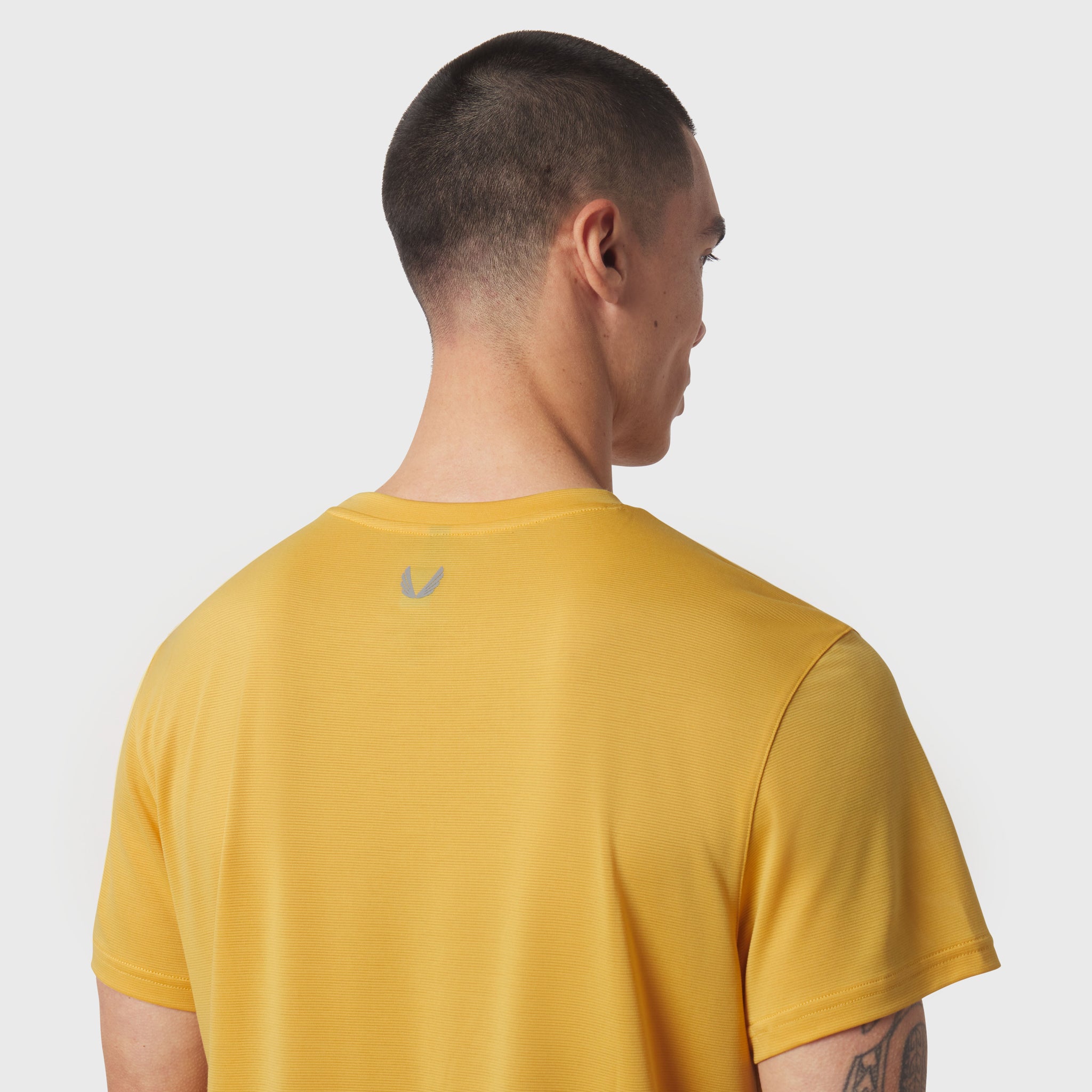 Polartec® Delta Training Tee in amber, worn by model shown from back