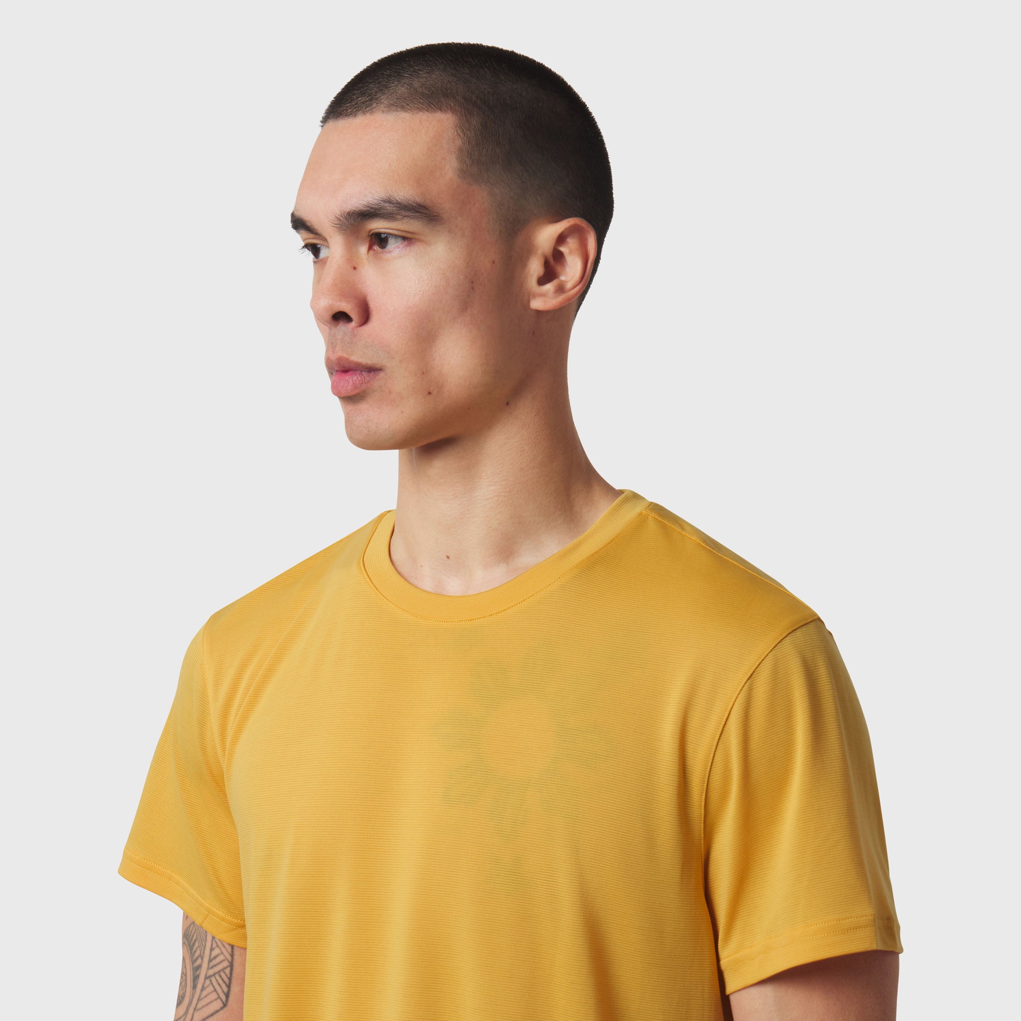 Polartec® Delta Training Tee in amber yellow worn by model, side profile view