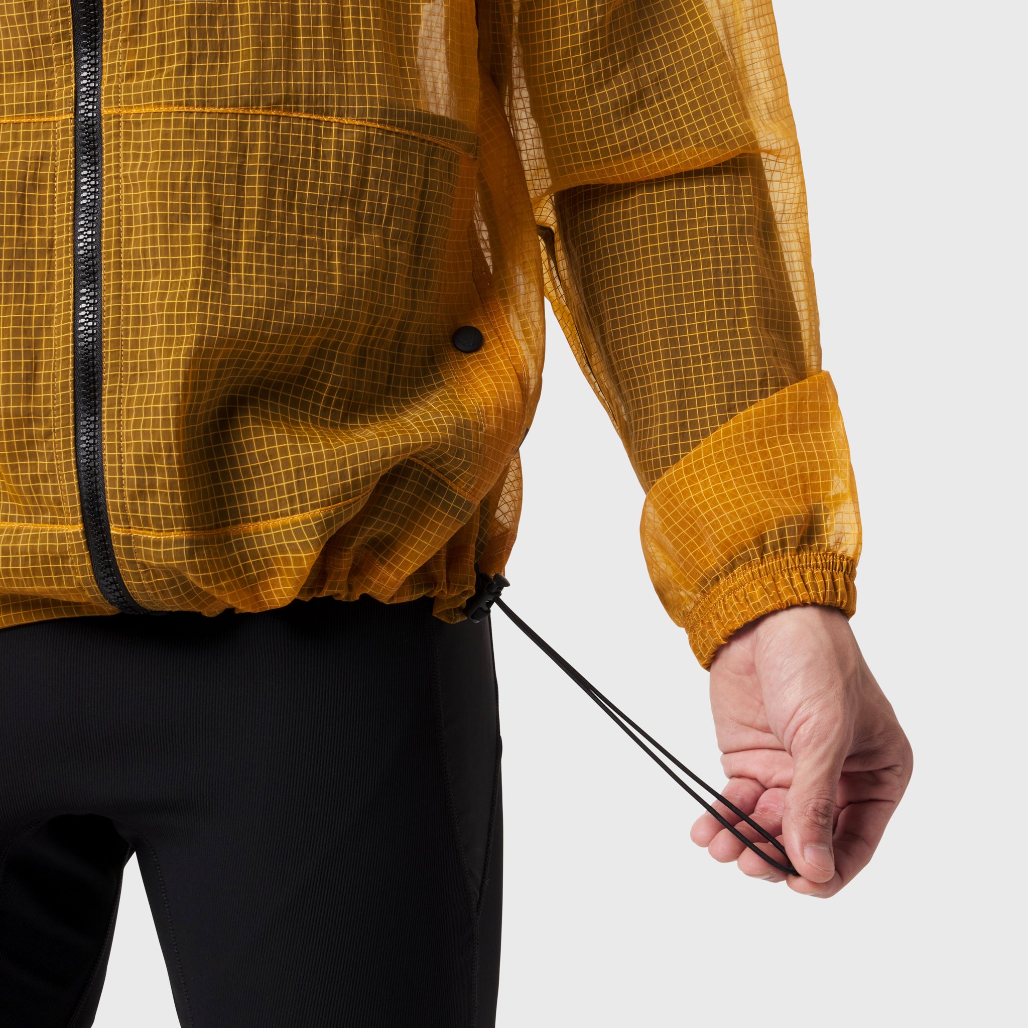 Weather-Ready Transparent Ripstop Shell Jacket in amber, worn by model showing drawcord detail
