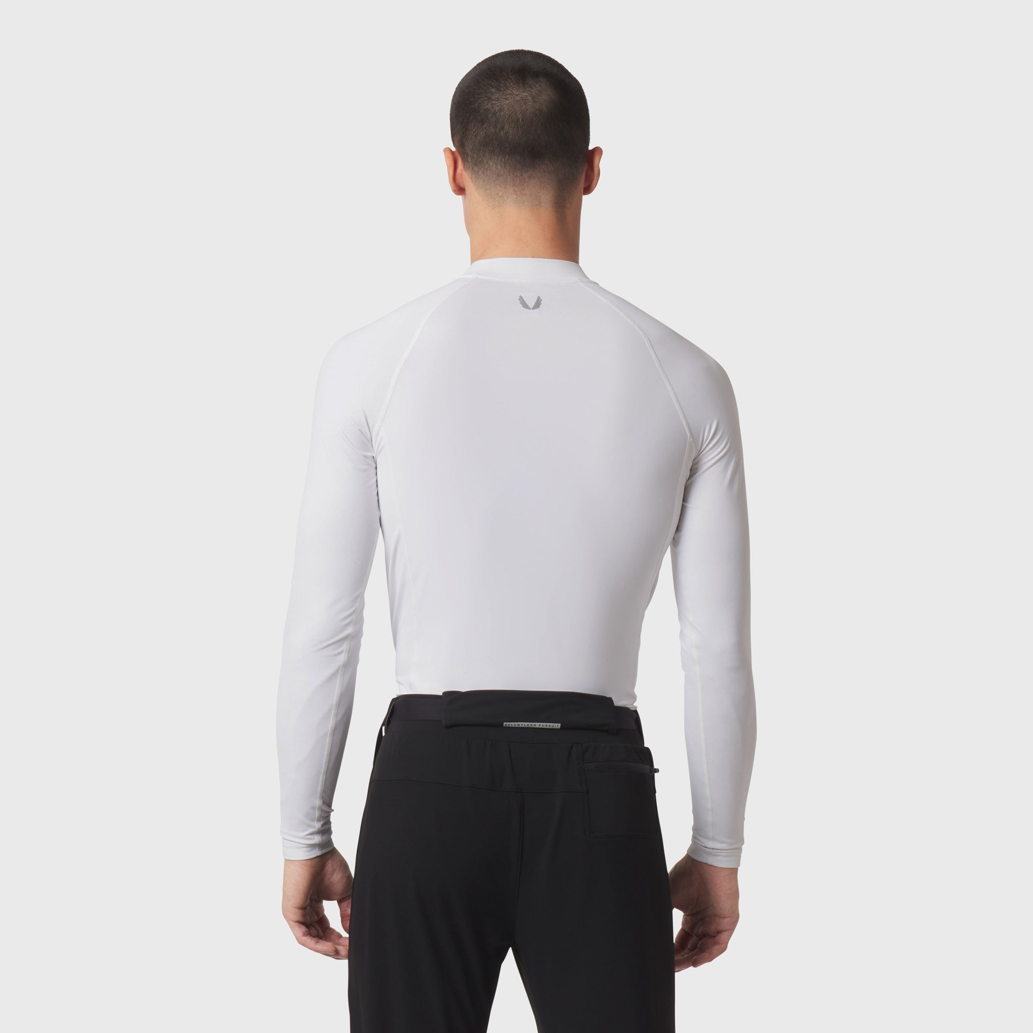 White LYCRA® ADAPTIV baselayer longsleeve worn by model, back view