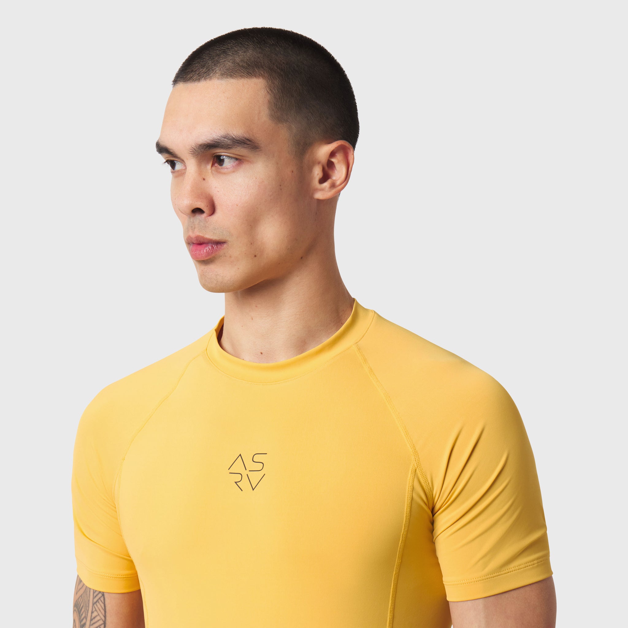 LYCRA® ADAPTIV Baselayer Shortsleeve in amber yellow, worn by model in profile view