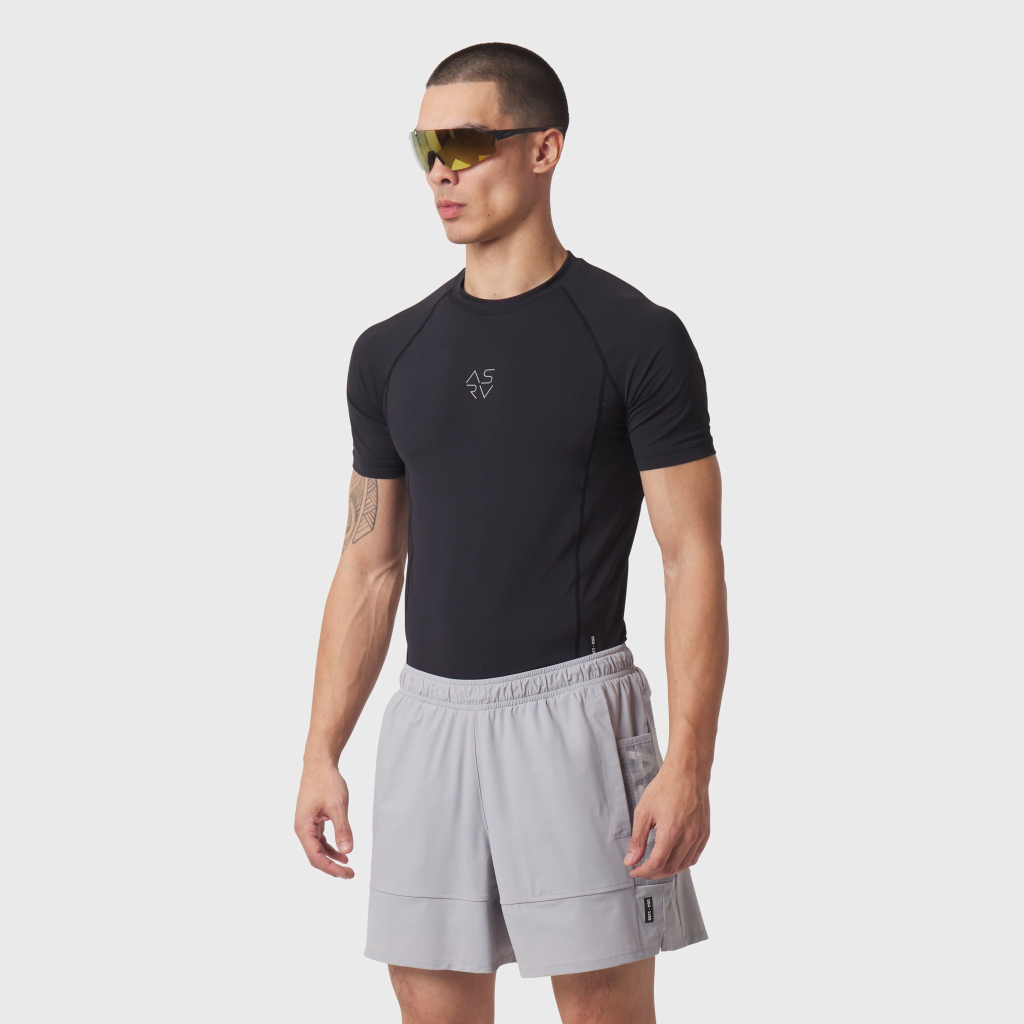 LYCRA® ADAPTIV Baselayer Shortsleeve in black worn with grey shorts, front view