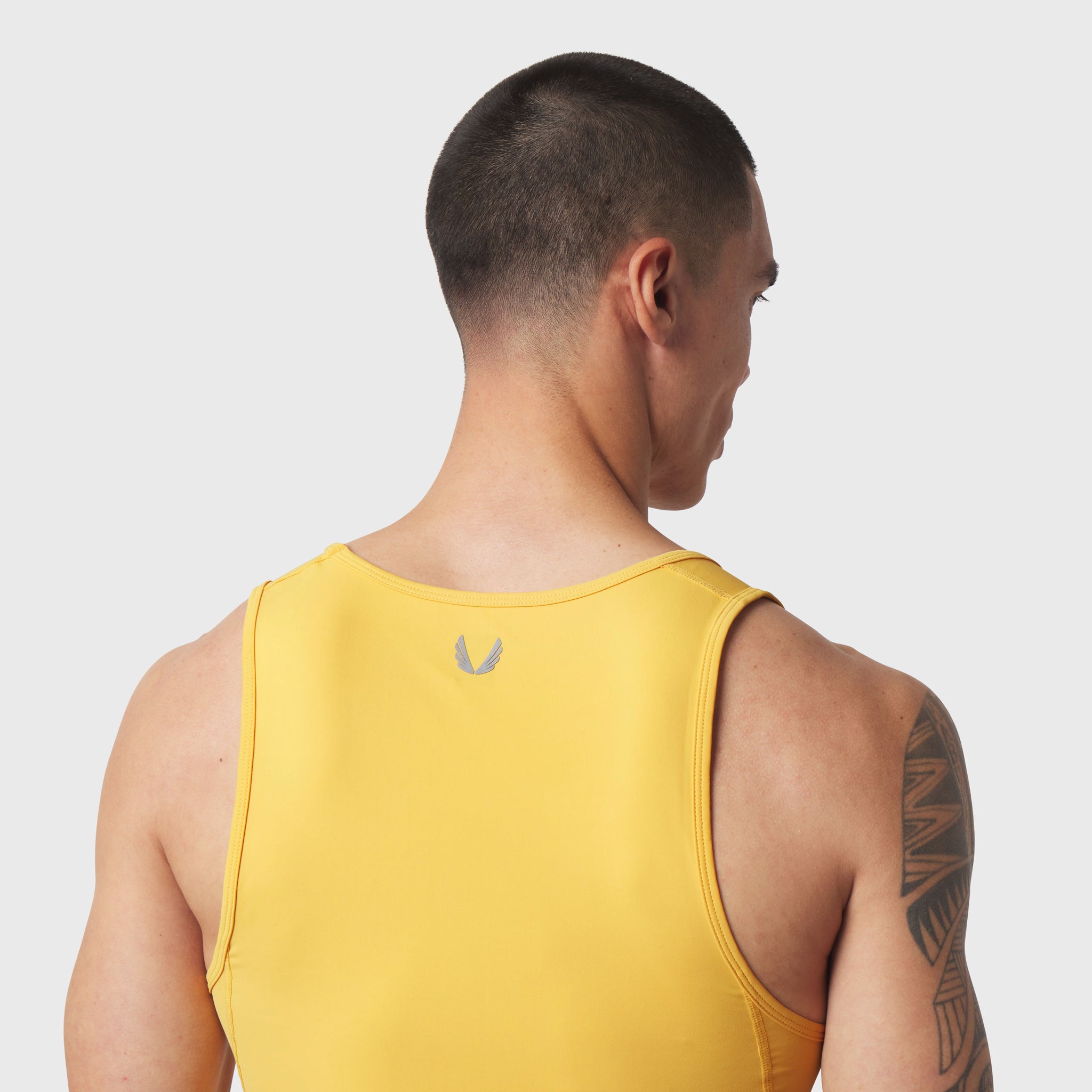 LYCRA® ADAPTIV Baselayer Tank in amber yellow, back view on model