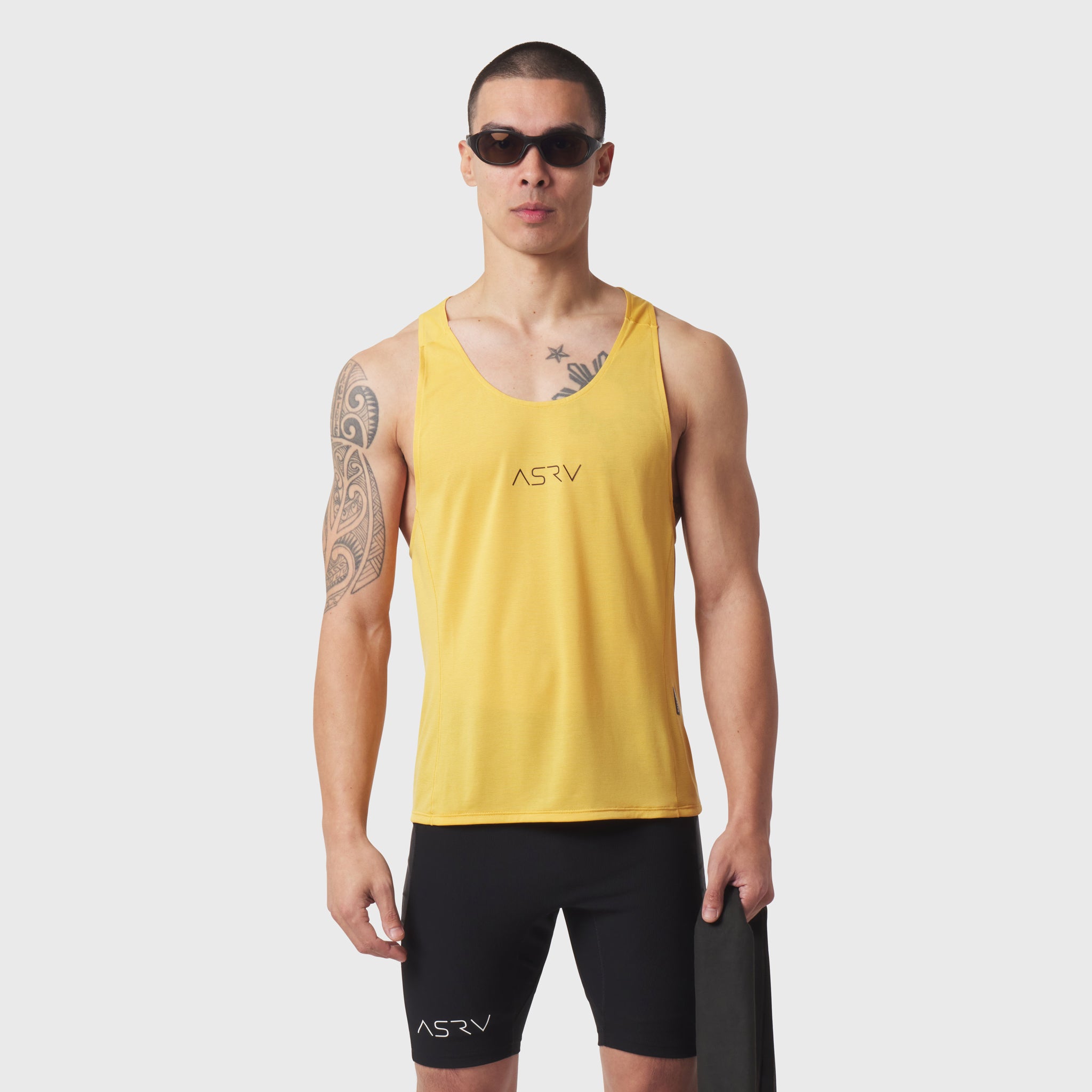Polartec® Delta Singlet in amber yellow worn by male model with black shorts, front view