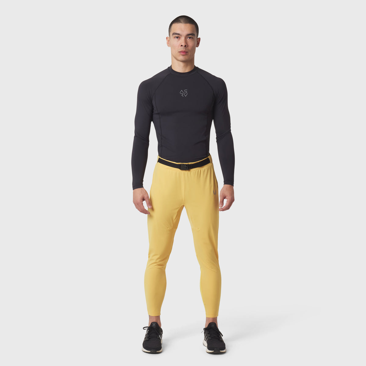 Hybrid Belt-Pack Run Jogger in amber yellow with black long-sleeve compression top, front view on model
