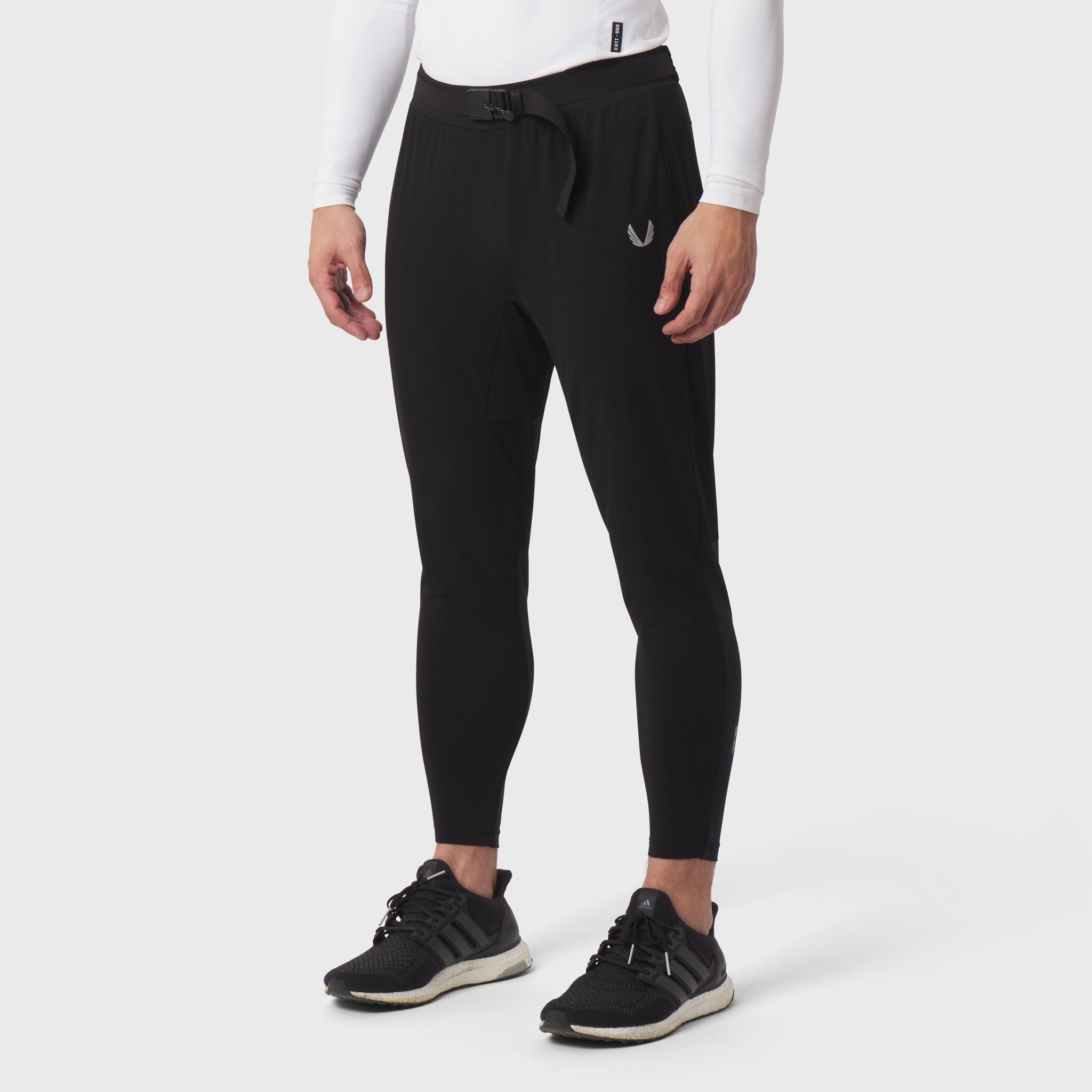 Black hybrid belt-pack run jogger worn by model with white long-sleeve shirt and black sneakers